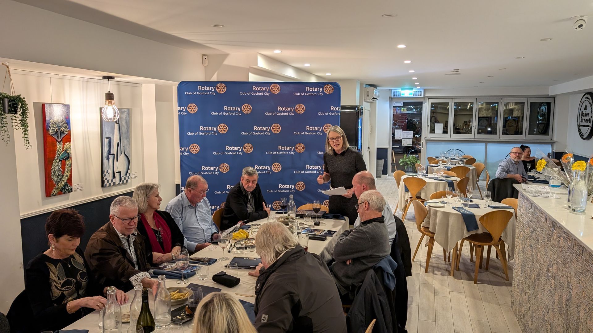 A group of people are sitting at tables in a restaurant.