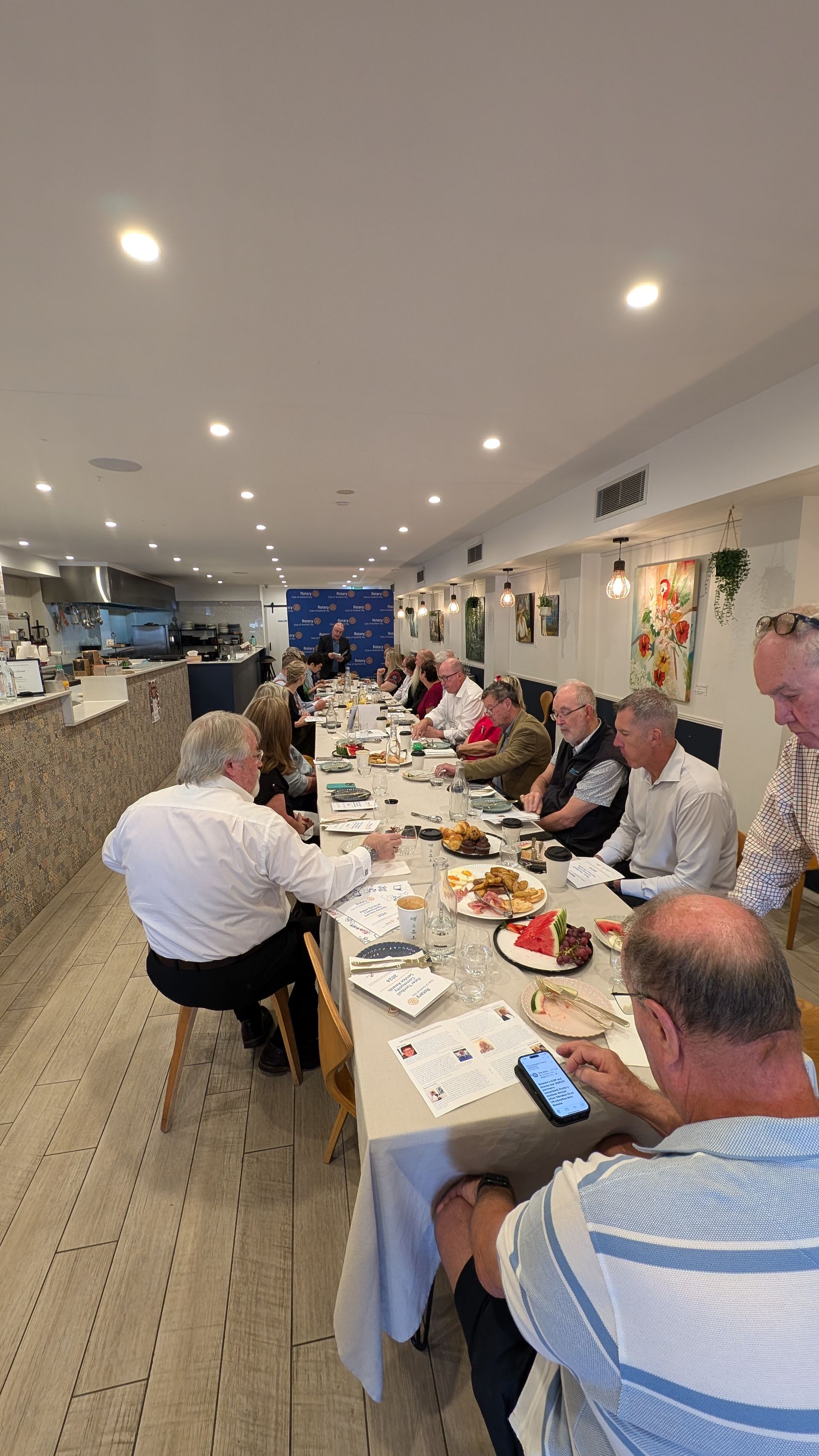 A group of people are sitting at a long table in a restaurant.