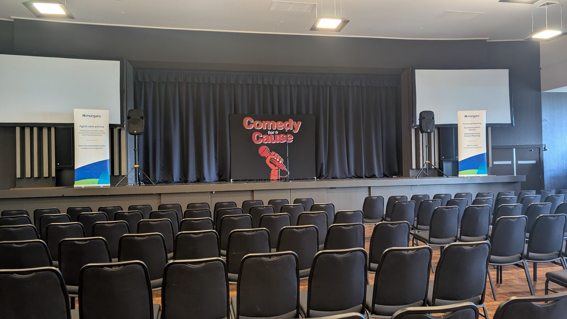 A large auditorium with rows of chairs and a stage.