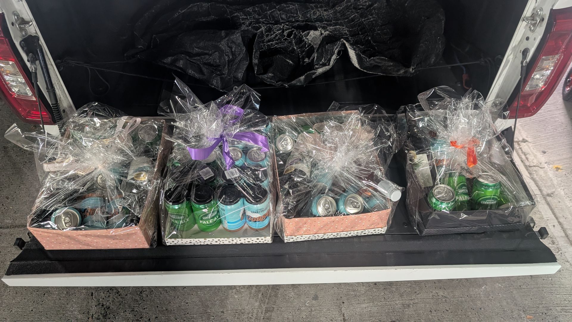 Three baskets wrapped in plastic are in the back of a truck.