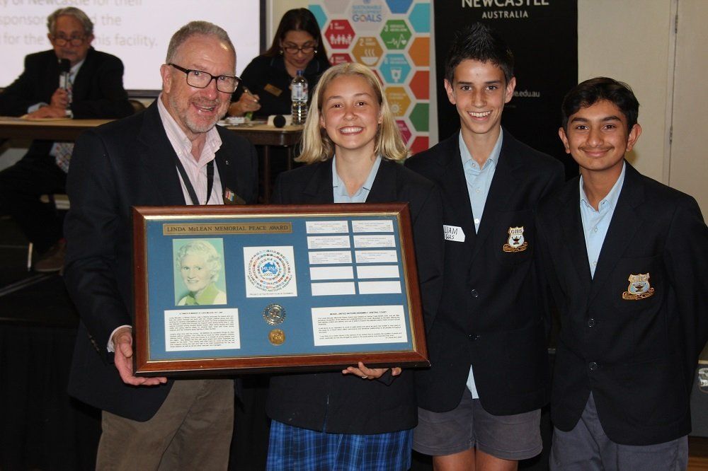 A group of people holding a framed picture of queen elizabeth ii