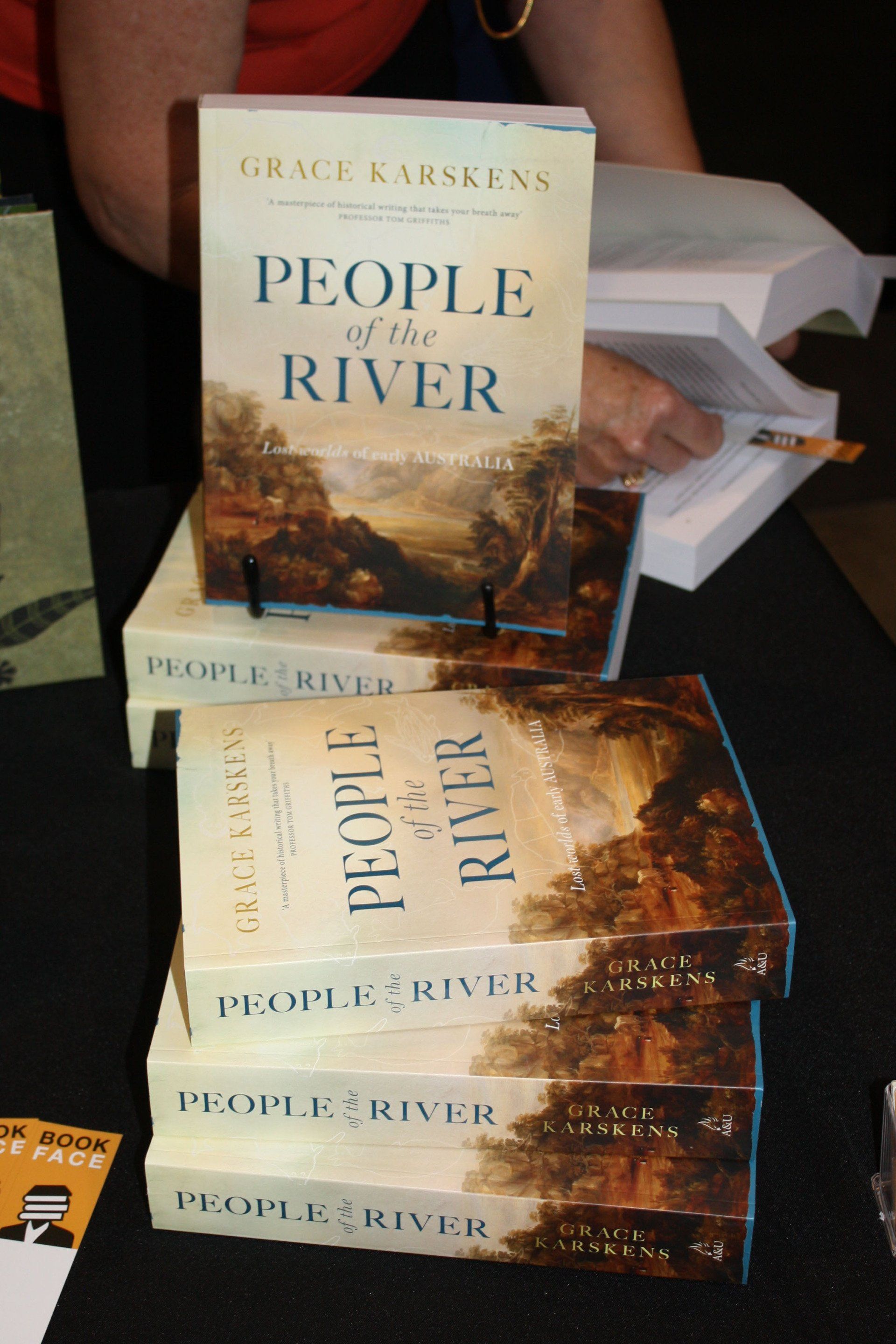 A stack of people of the river books on a table
