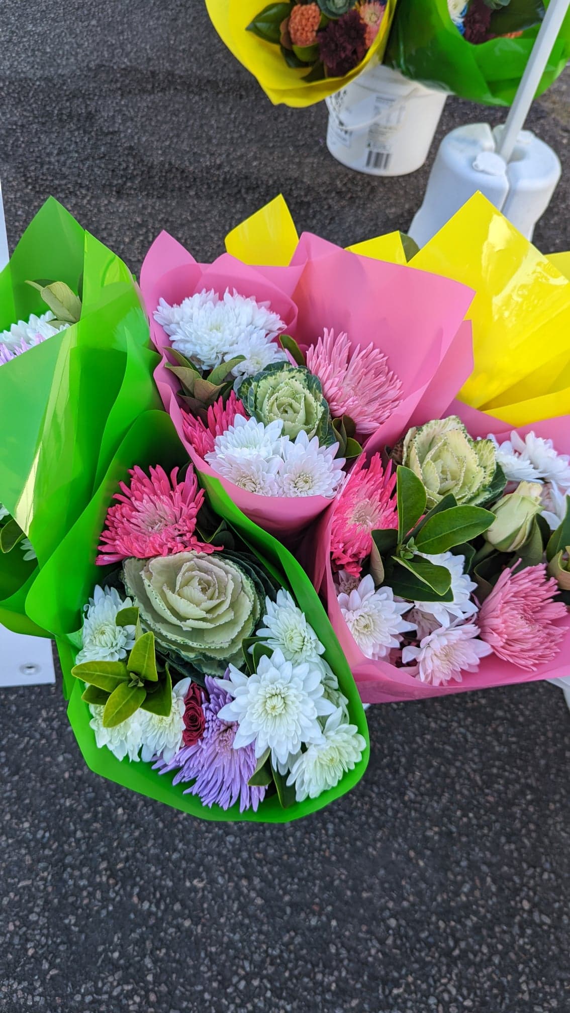 A bunch of bouquets of flowers are sitting on the ground.
