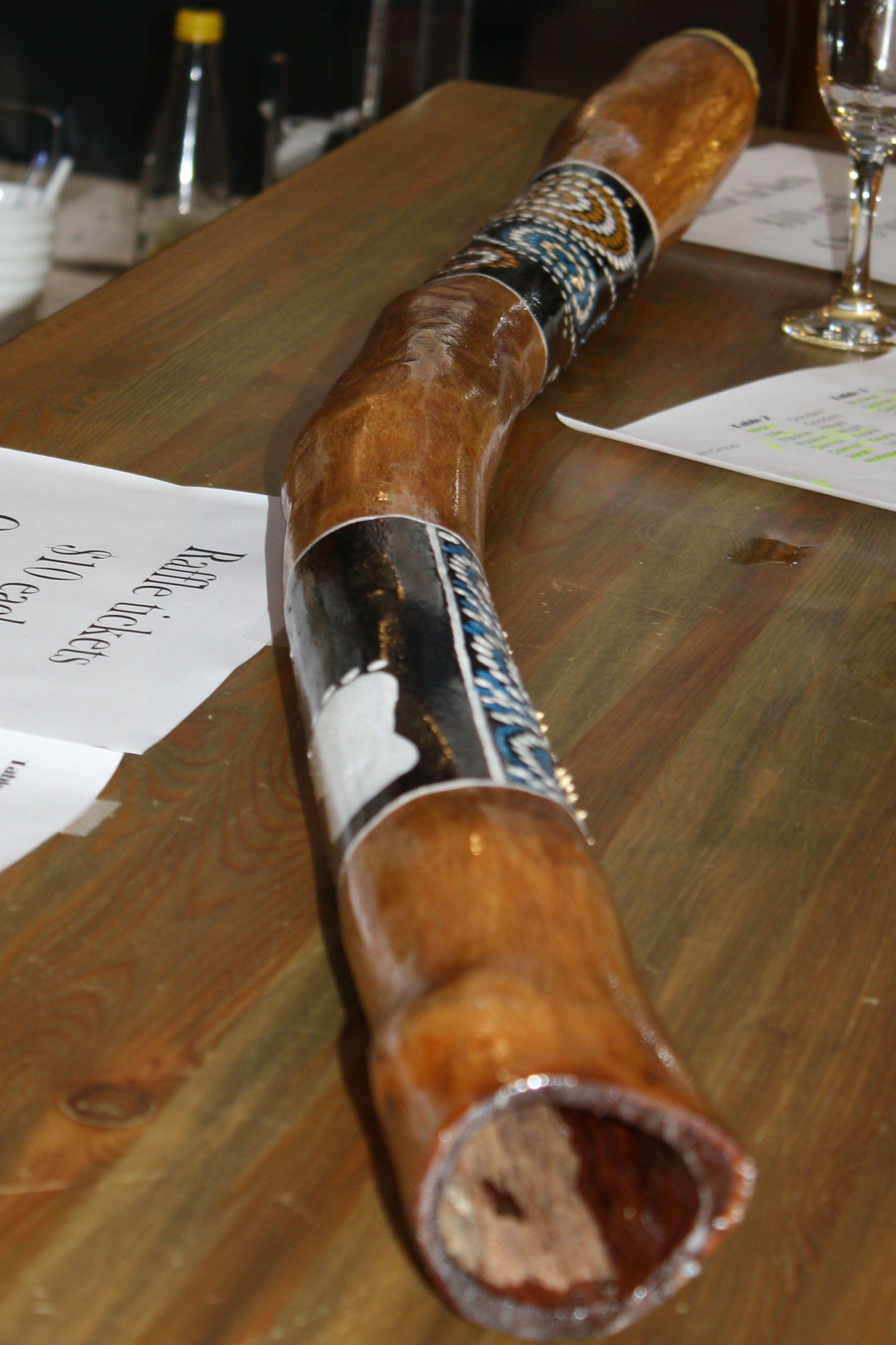 A long wooden instrument is sitting on a wooden table