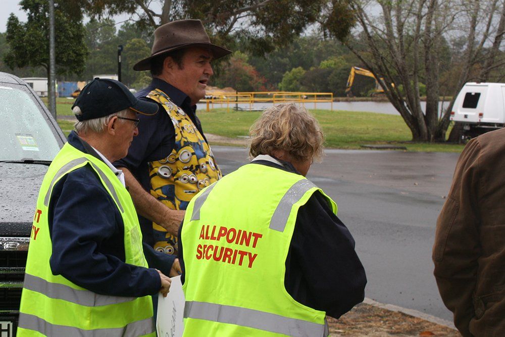 Two men wearing yellow vests that say allpoint security