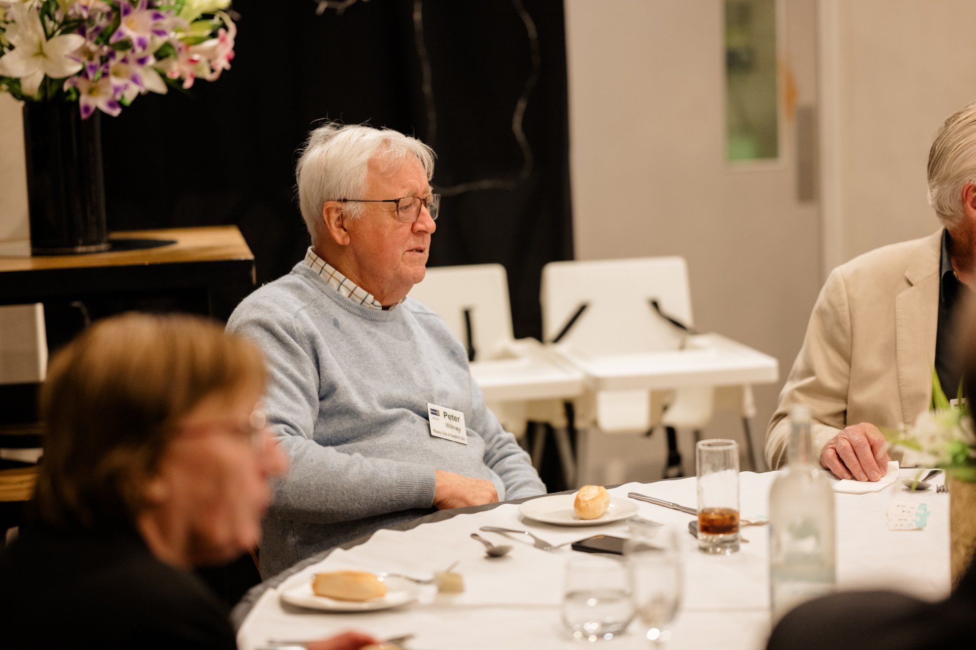 A group of people are sitting at a table with plates of food.