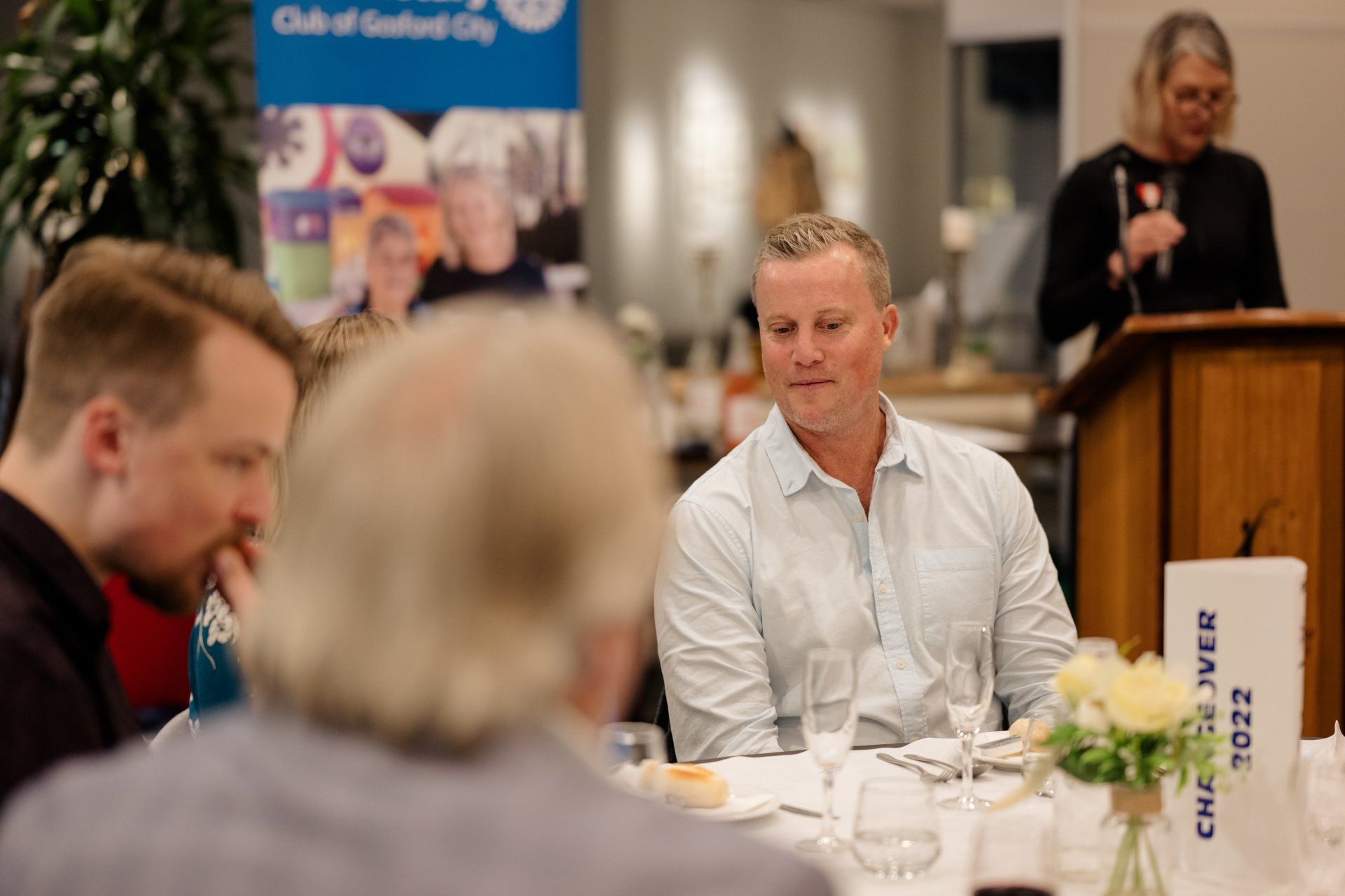 A group of people are sitting at a table talking to each other.