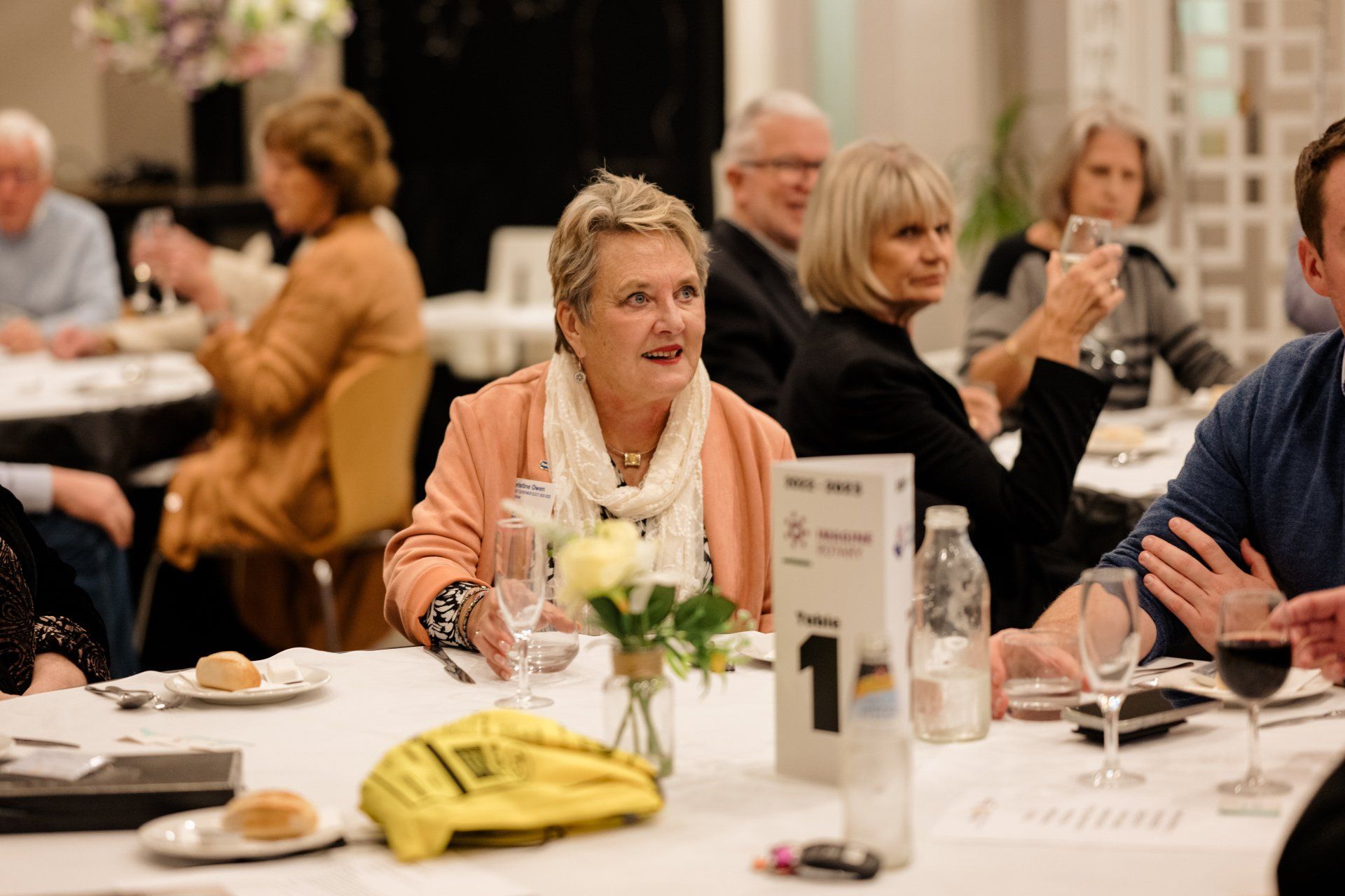 A group of people are sitting at tables in a restaurant.