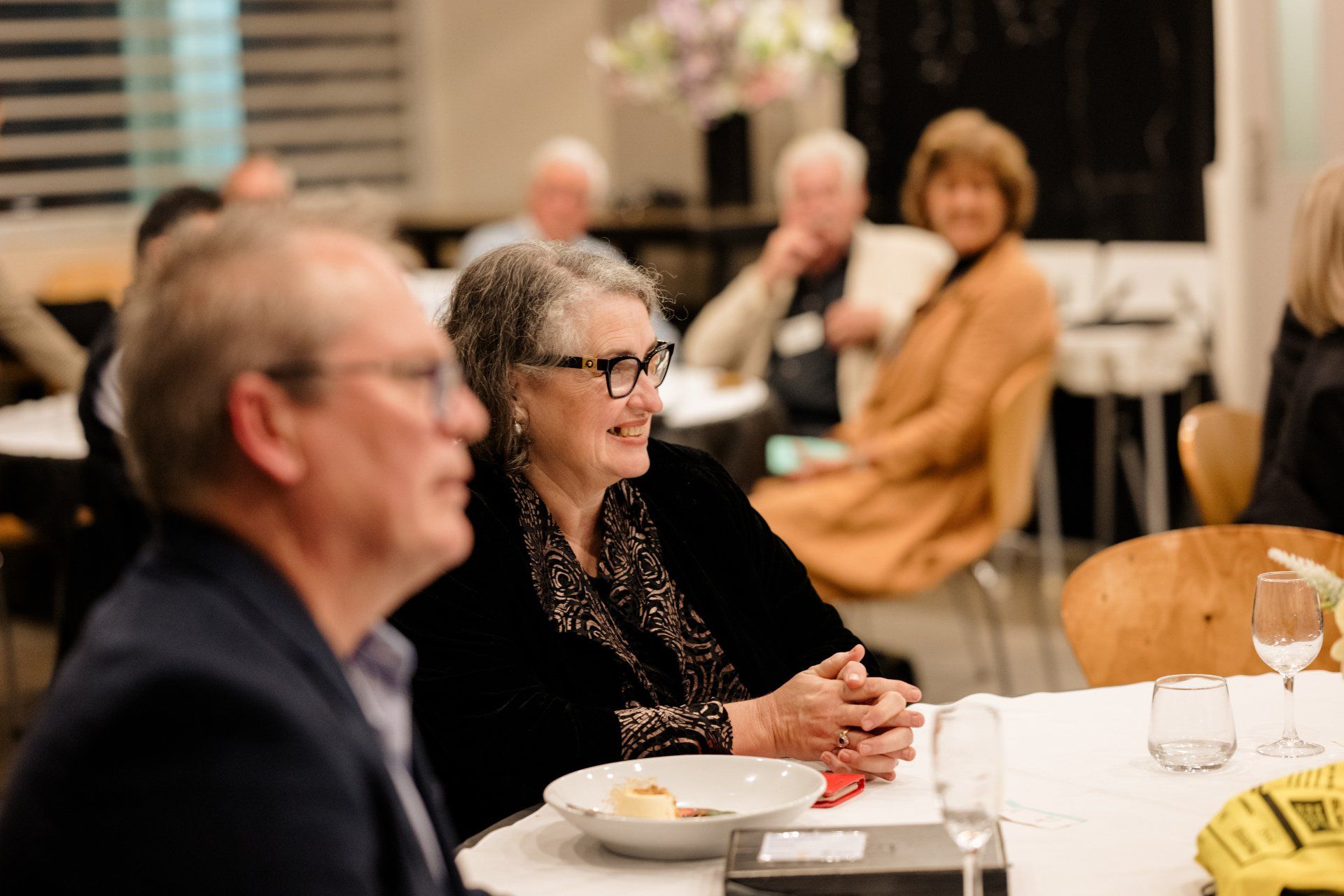 A group of people are sitting at a table with plates of food.