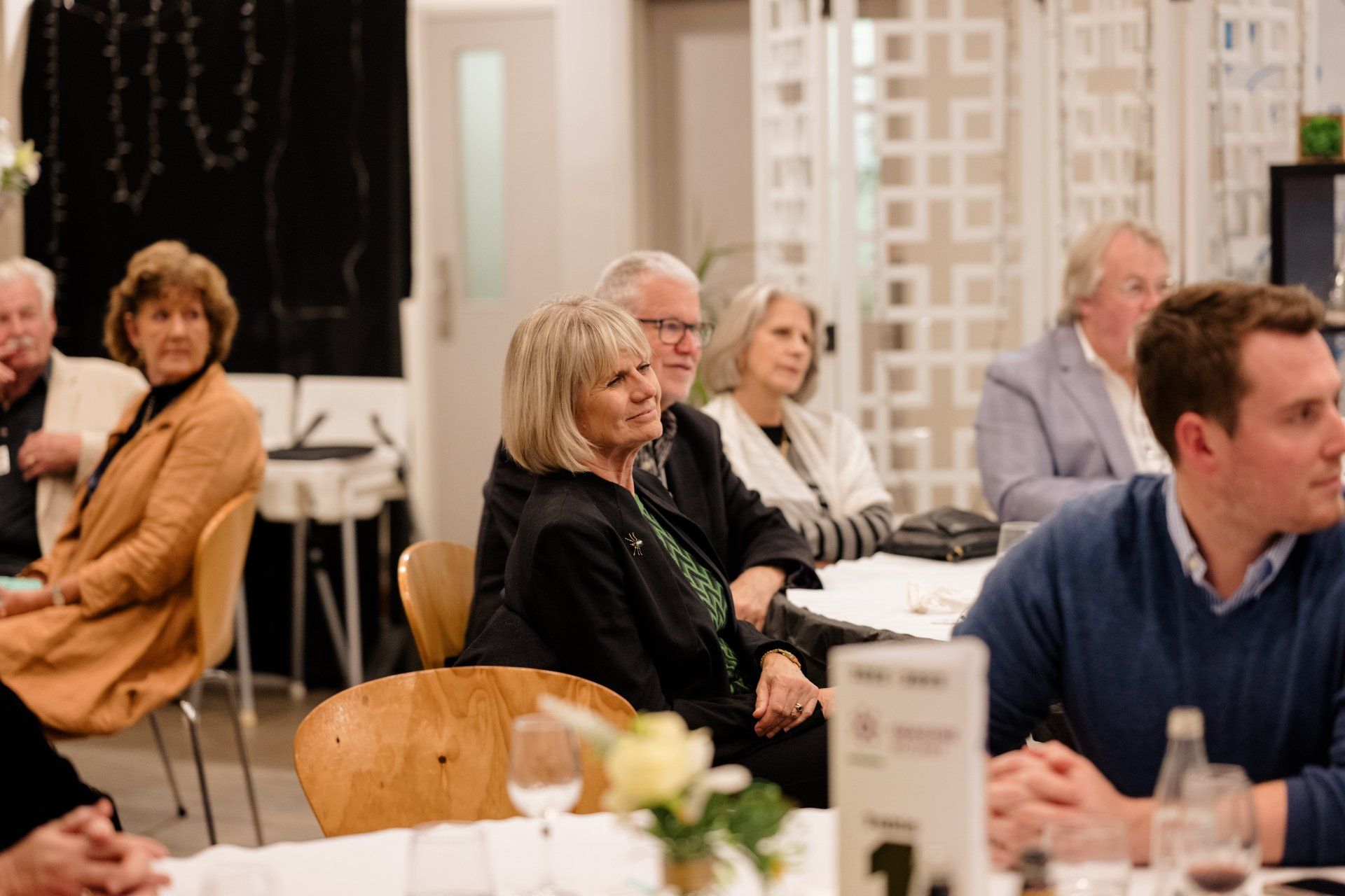 A group of people are sitting at tables in a room.
