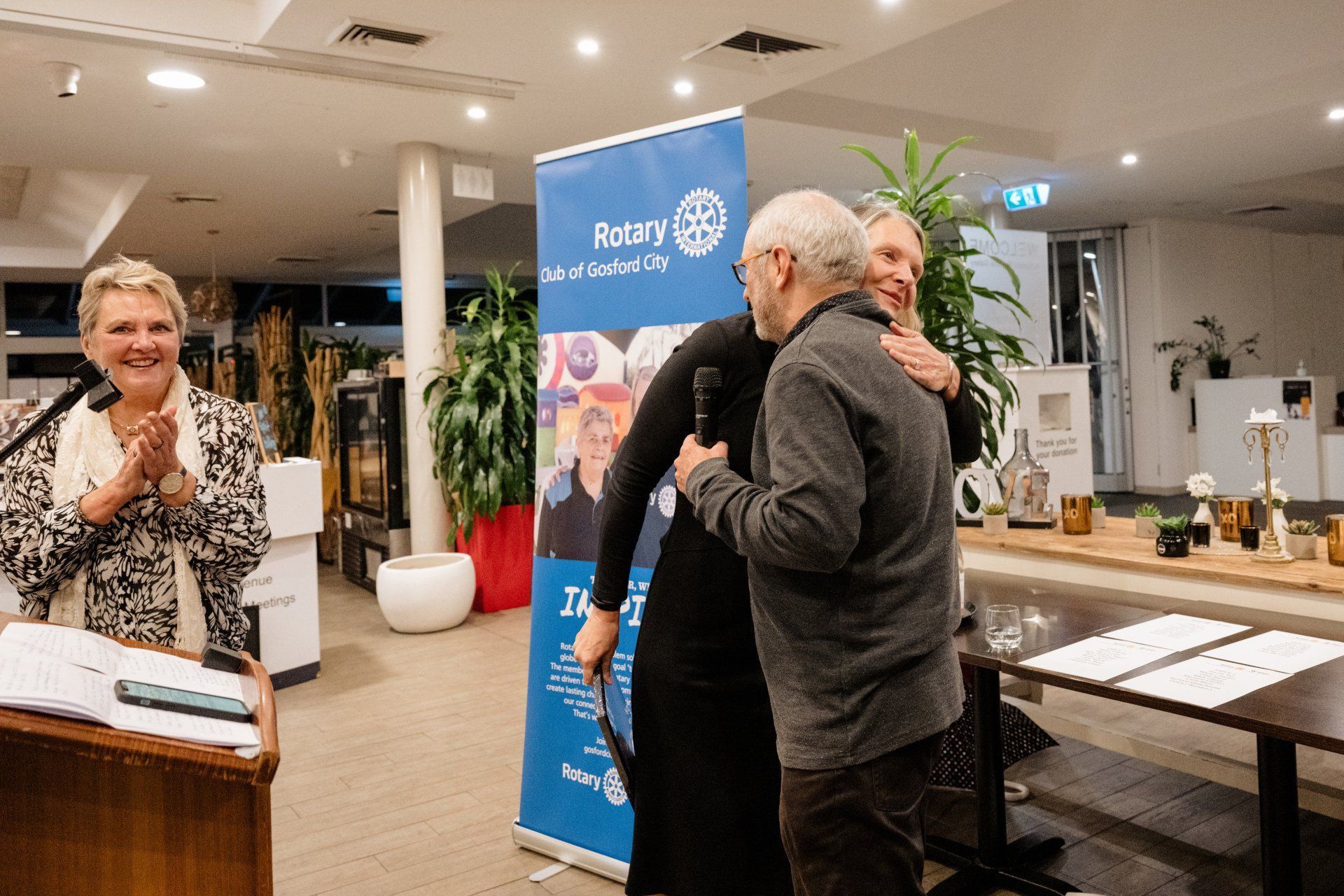 A group of people are hugging each other in a room.