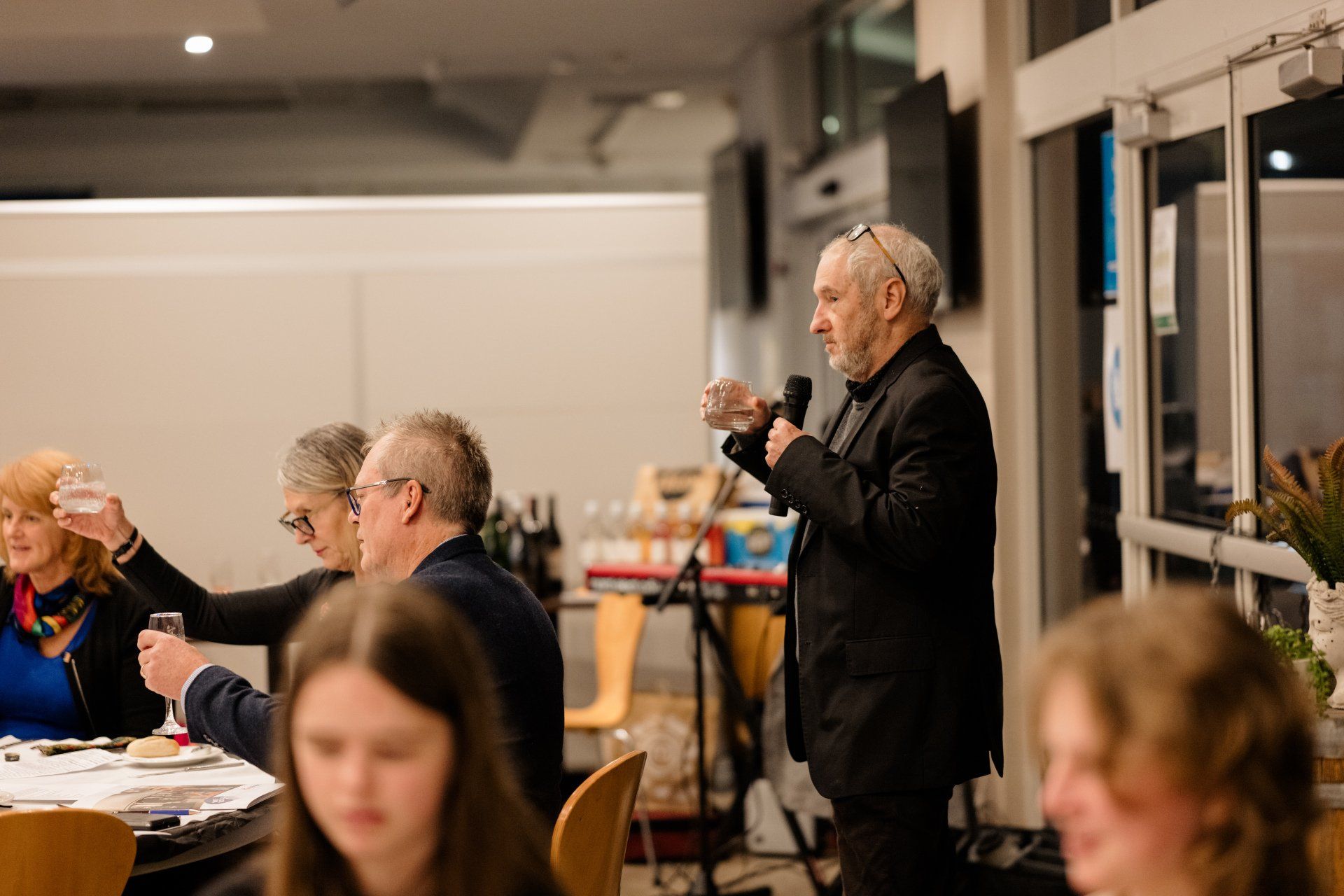 A man is holding a microphone in front of a group of people.