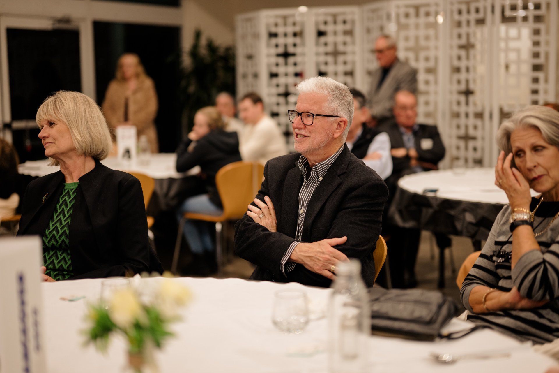 A group of people are sitting at tables in a room.