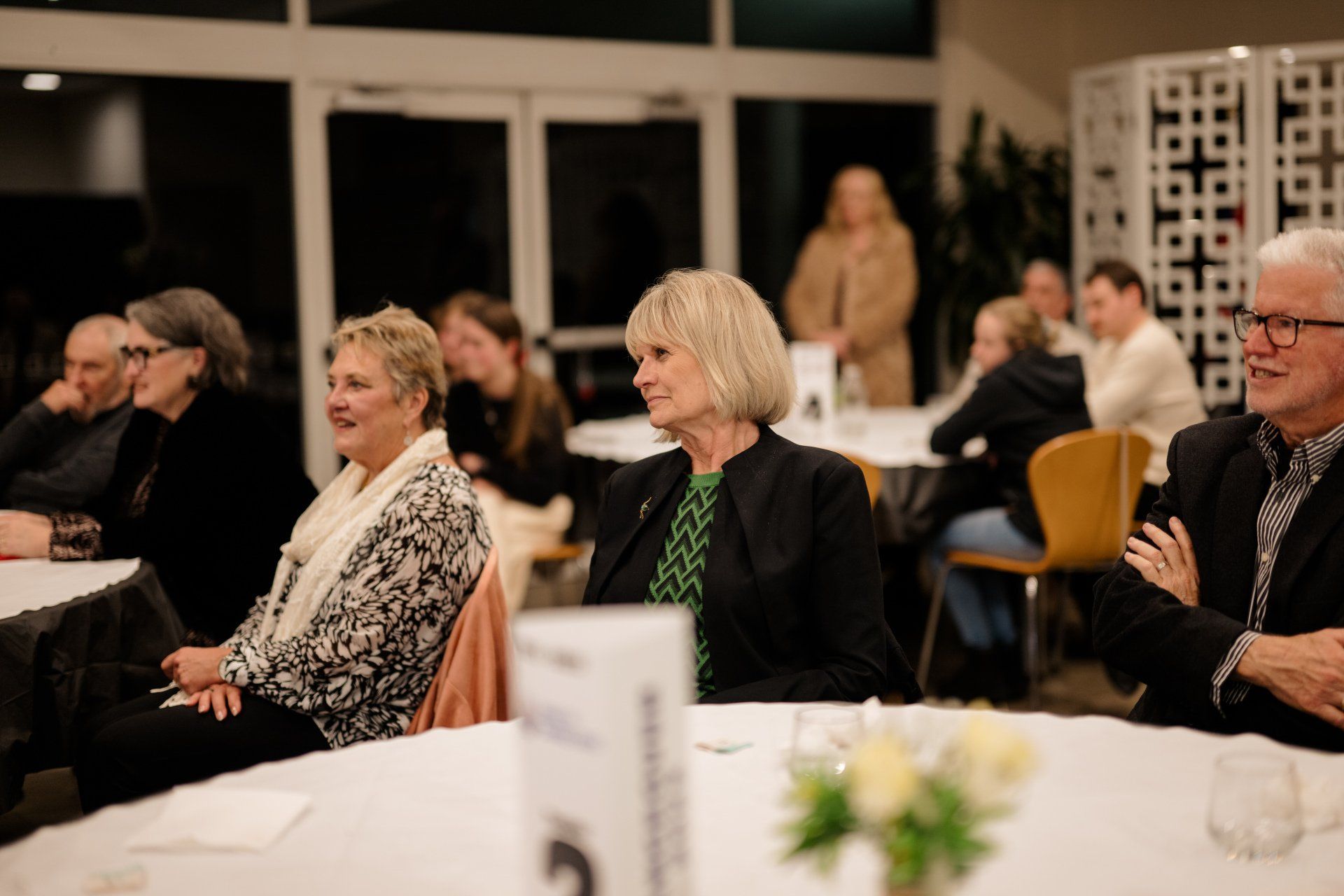 A group of people are sitting at tables in a room.