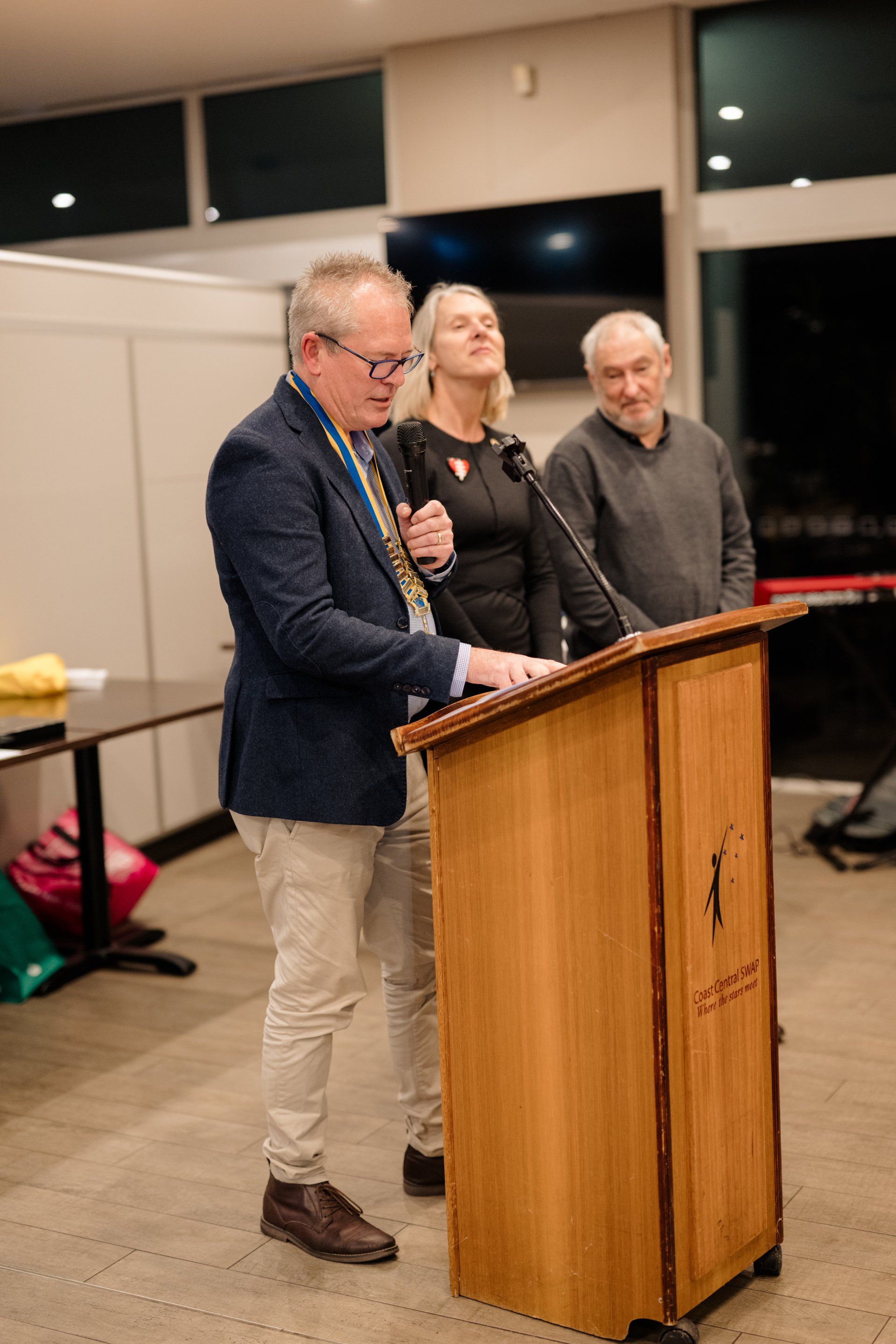 A man is standing at a podium talking into a microphone.