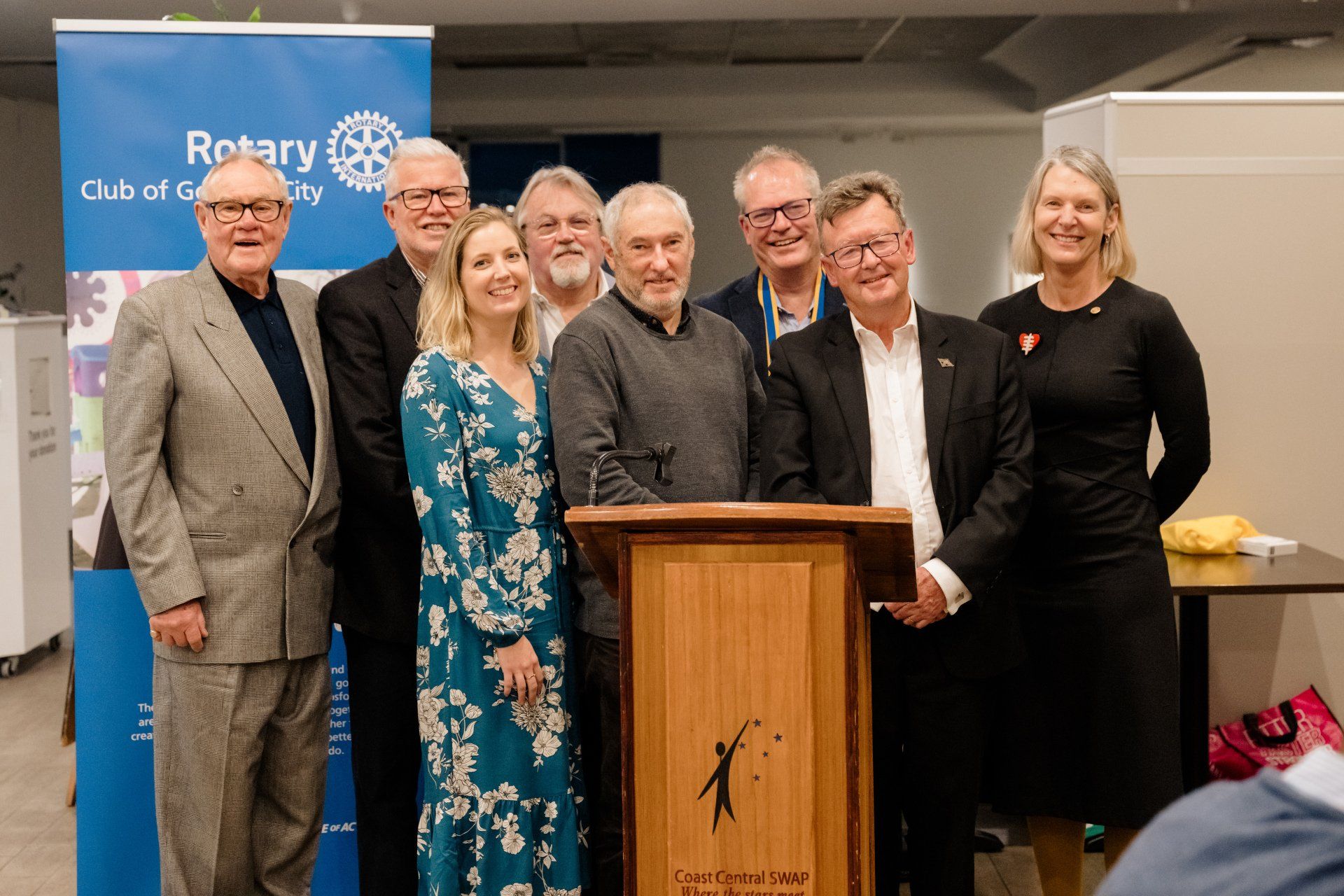 A group of people are standing around a podium.