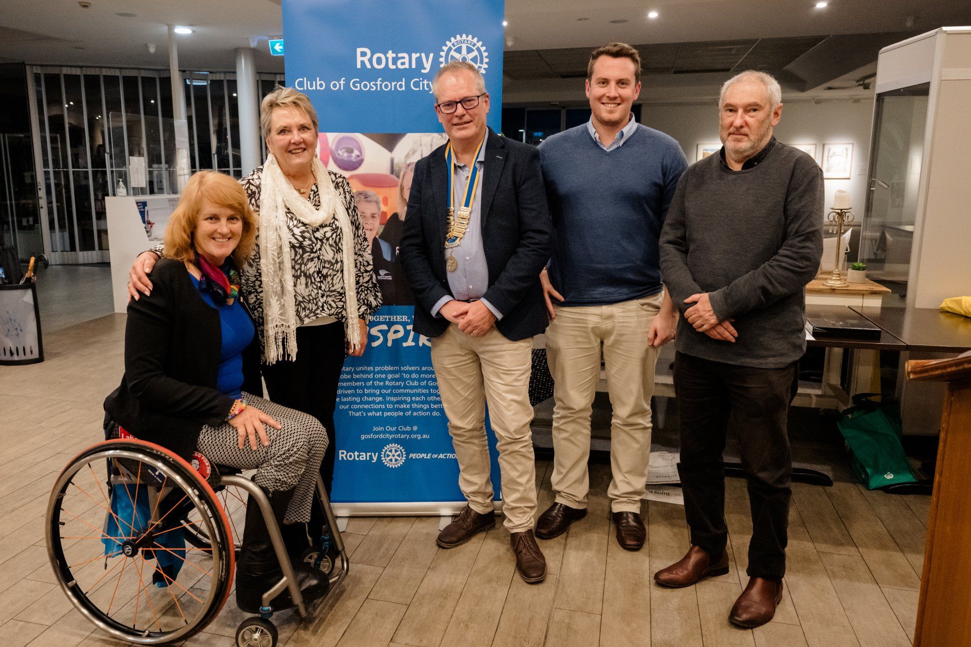 A woman in a wheelchair is standing next to a group of people.