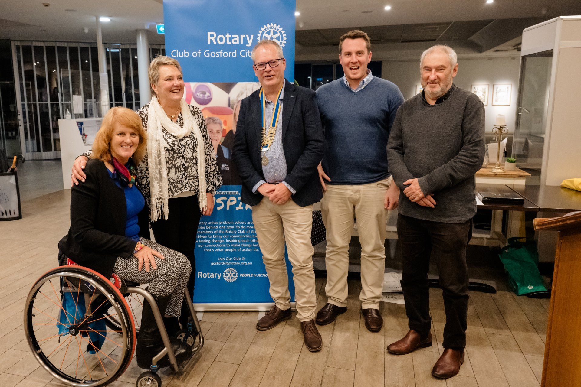 A woman in a wheelchair is standing next to a group of people.
