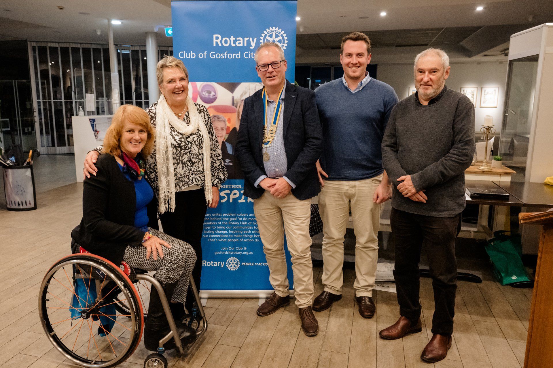 A woman in a wheelchair is standing next to a group of people.