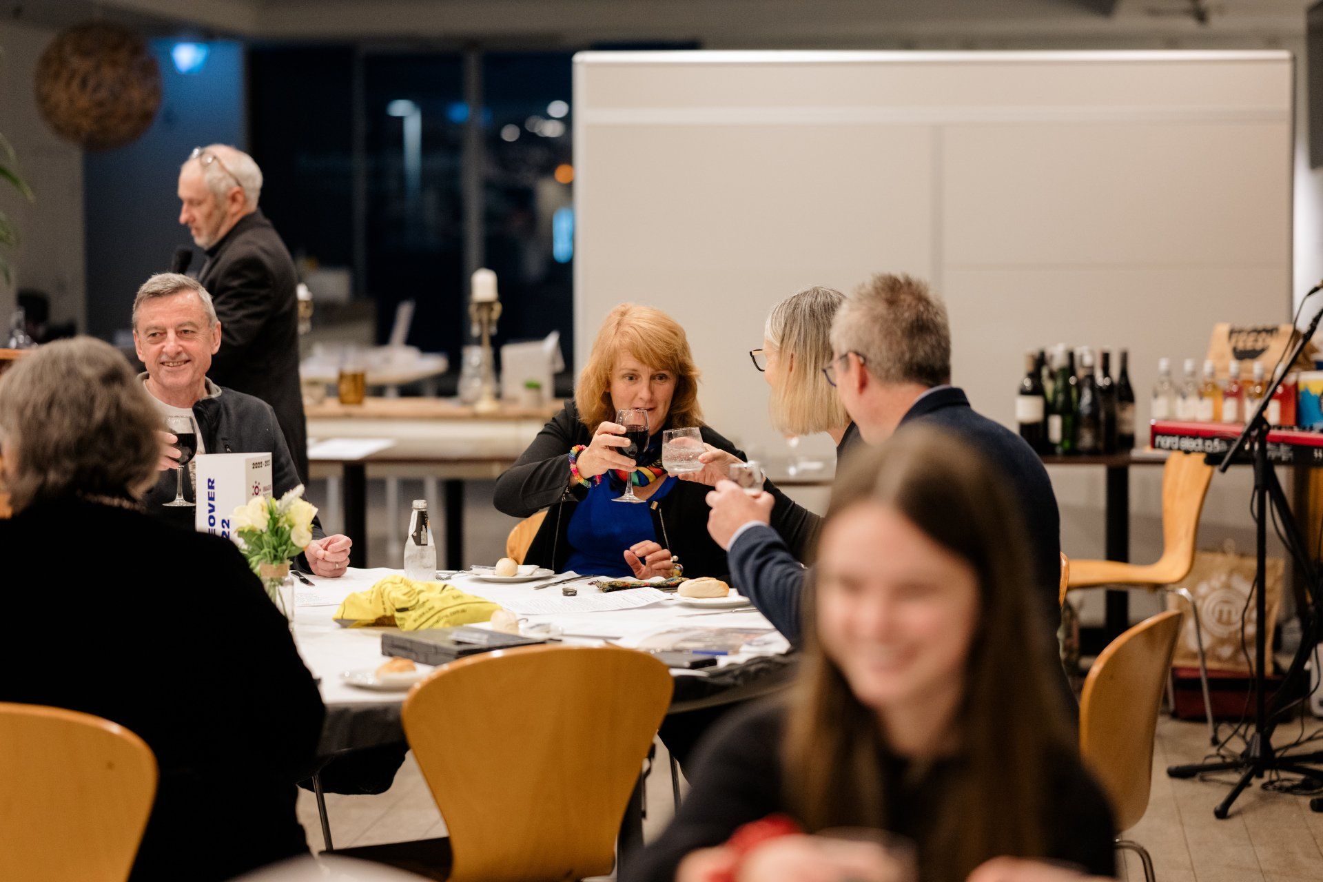 A group of people are sitting at a table drinking wine.
