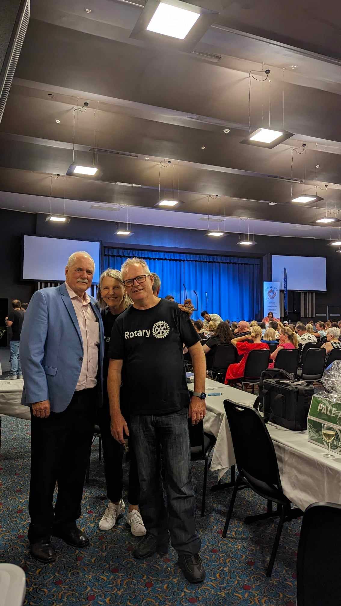 A group of people are posing for a picture in a large room.