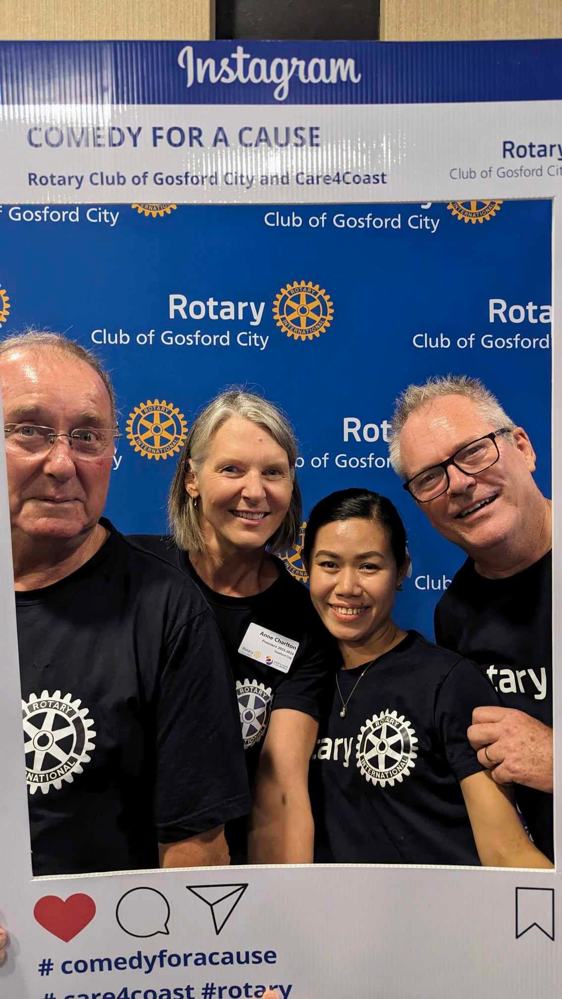 A group of people are posing for a picture in front of a sign that says comedy for a cause.