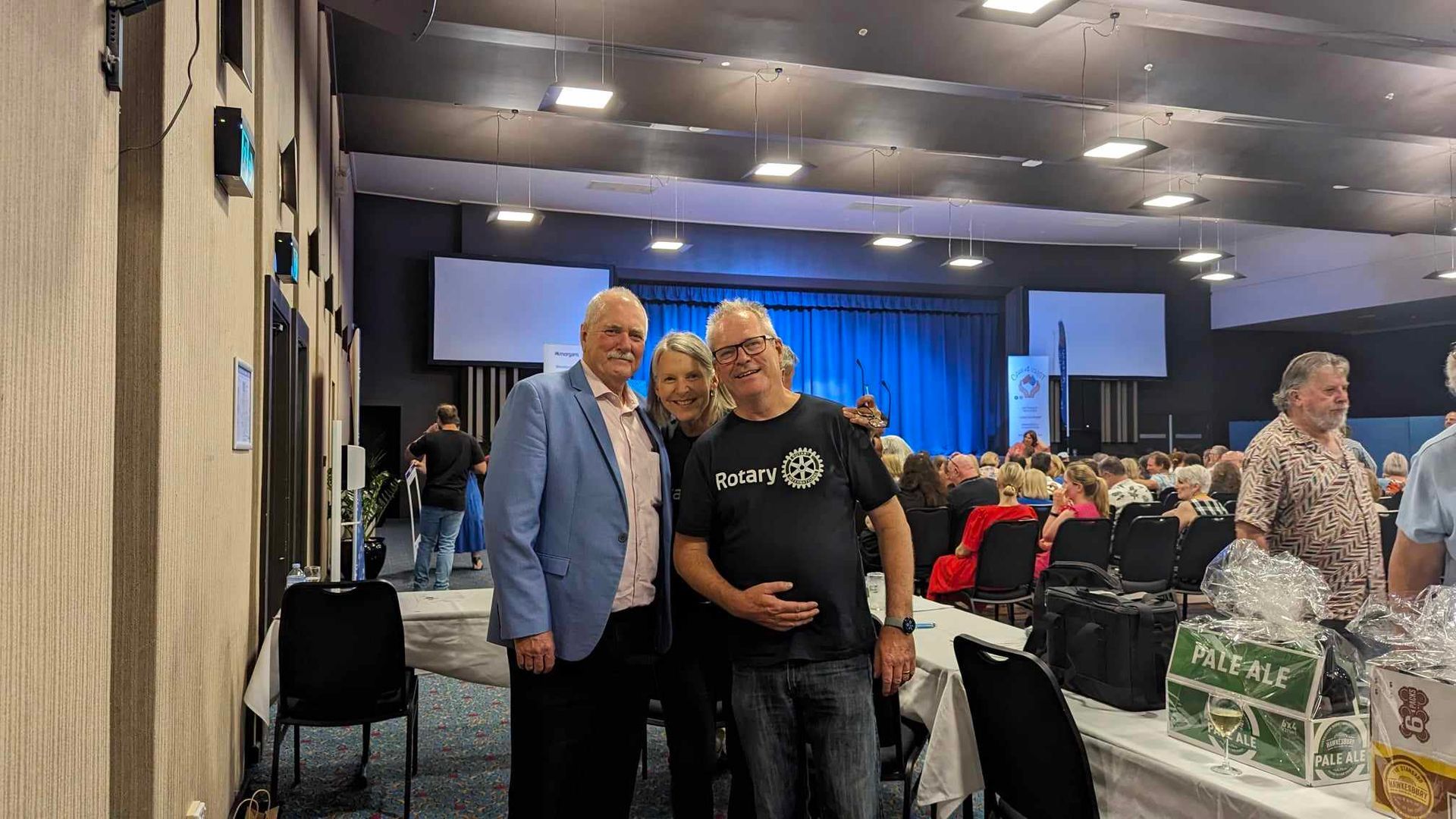 A group of people are posing for a picture in a large room.