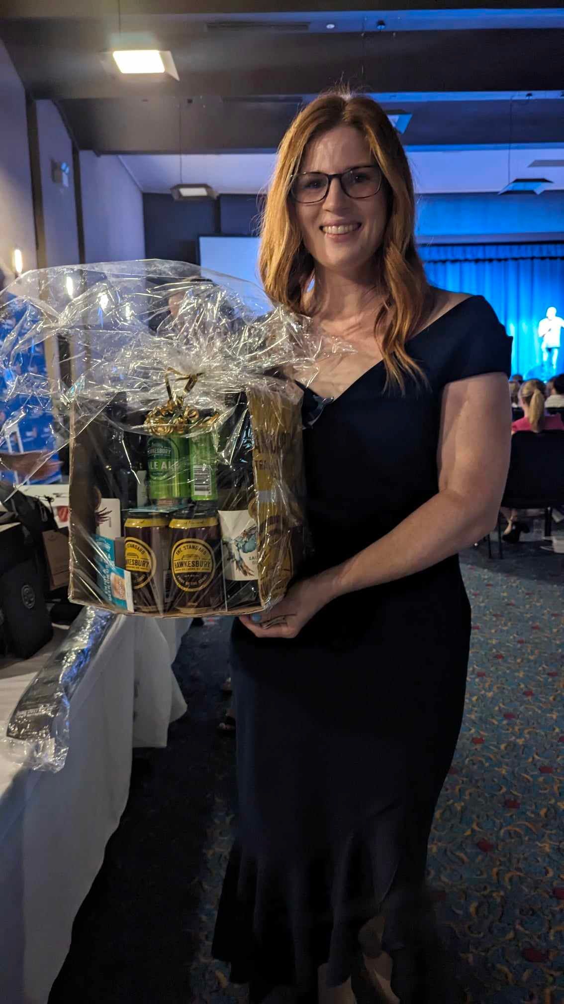 A woman in a black dress is holding a basket of food.