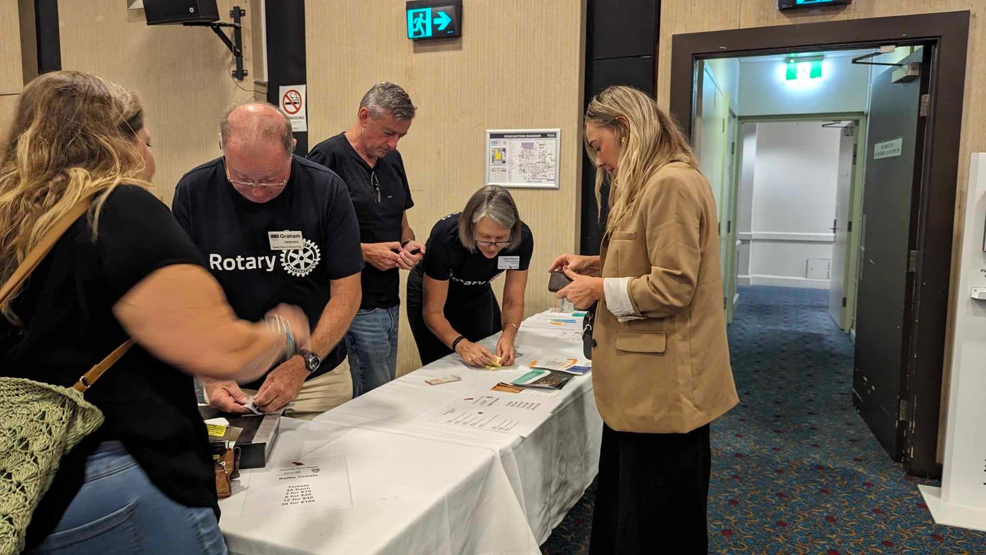 A group of people are standing around a table in a room.