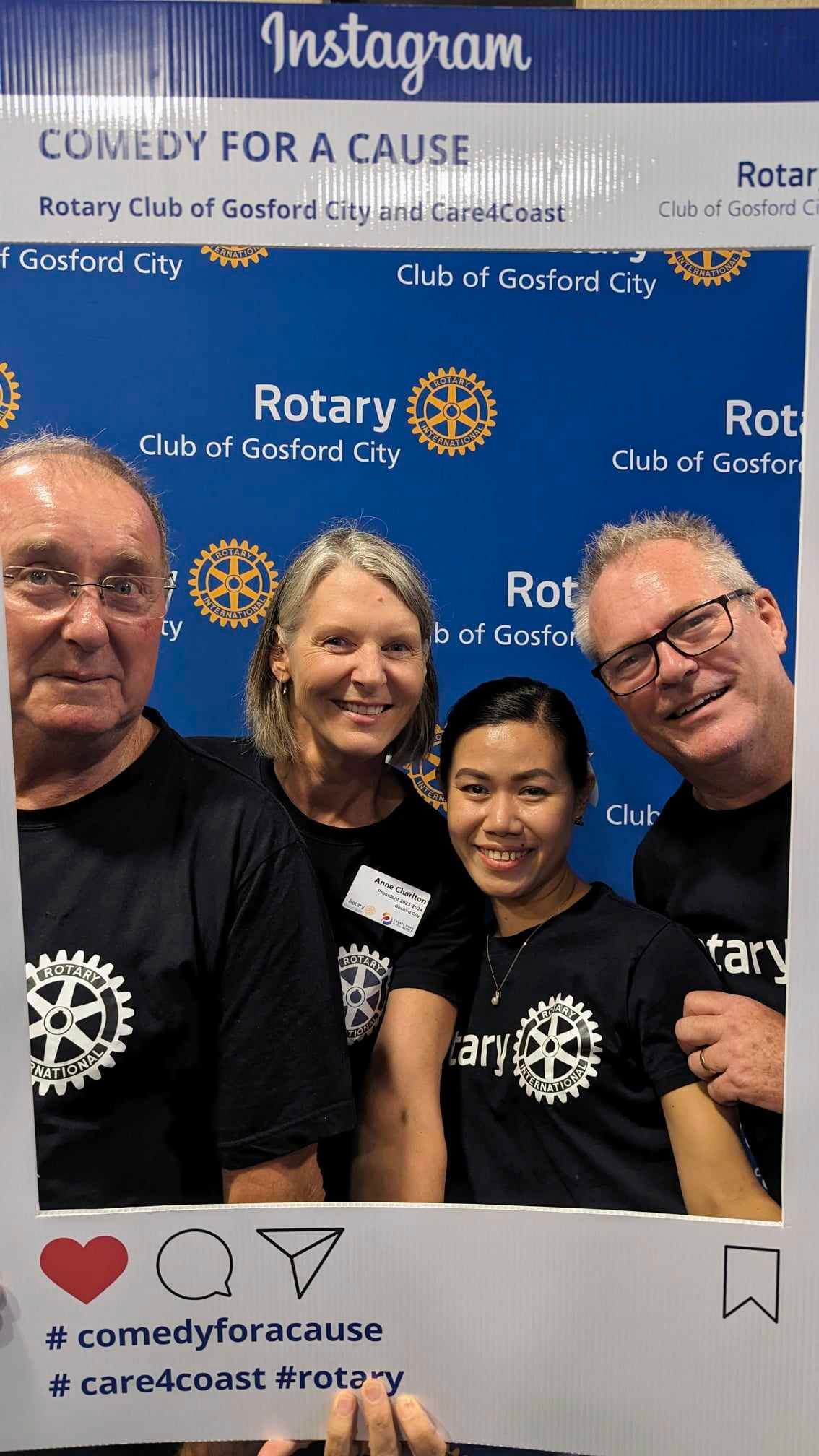 A group of people are posing for a picture in front of a sign that says instagram comedy for a cause.
