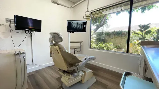 A dental office with a dental chair and a television.