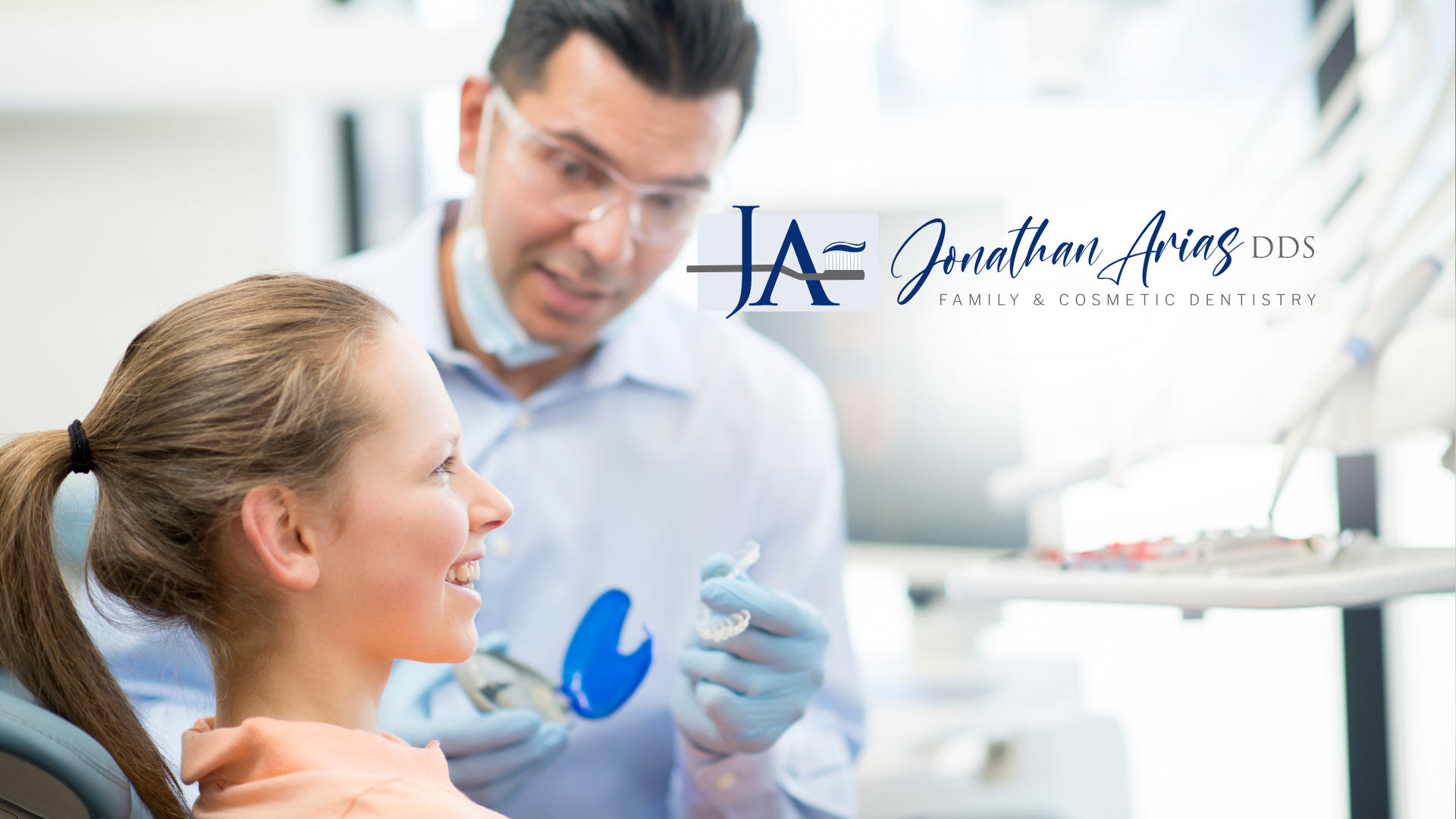A woman is sitting in a dental chair talking to a dentist.
