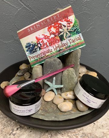 Holiday facial spa gift set with two jars, pink brush, stones, and a festive card display