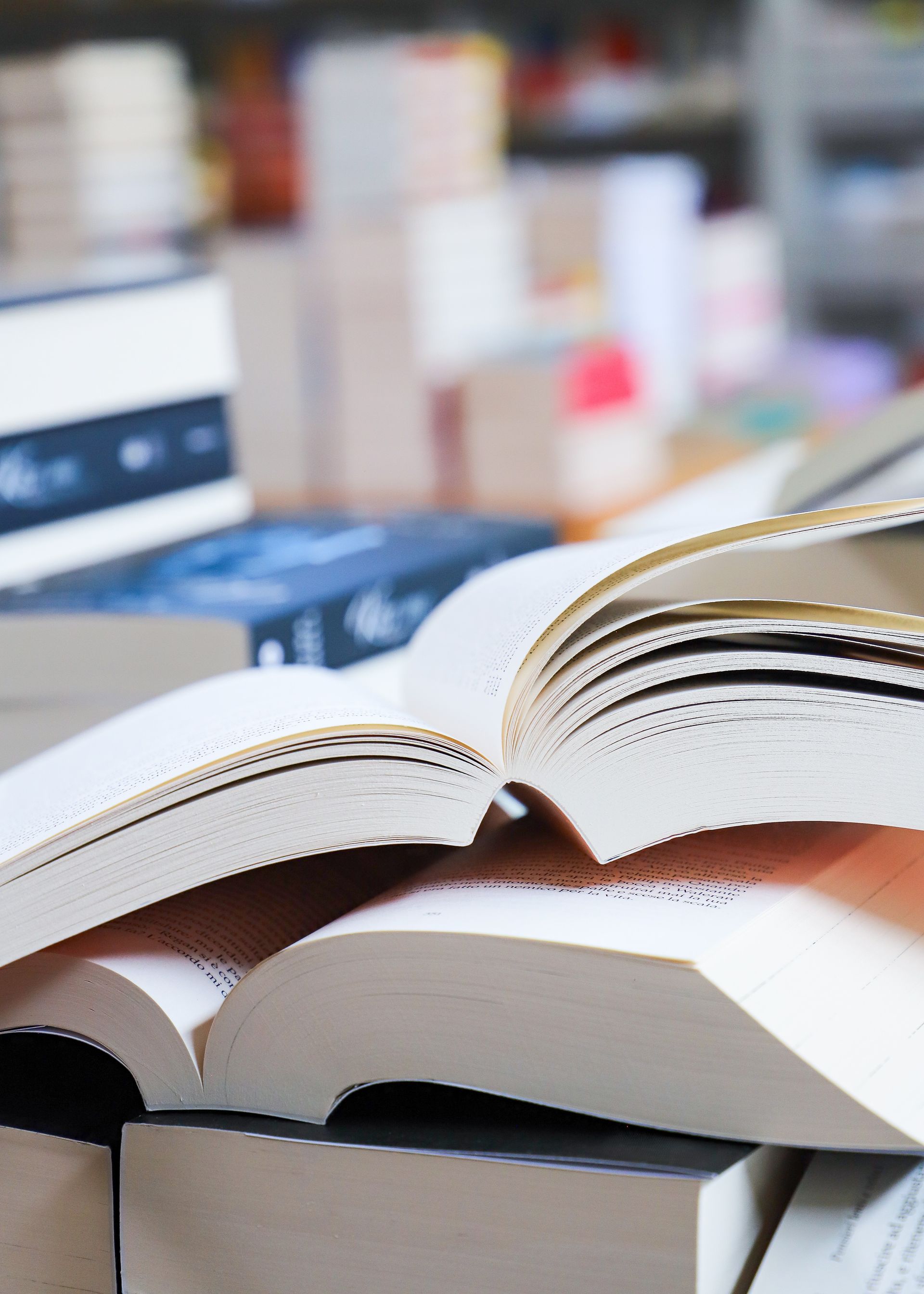 A stack of books on a table with a red book on top