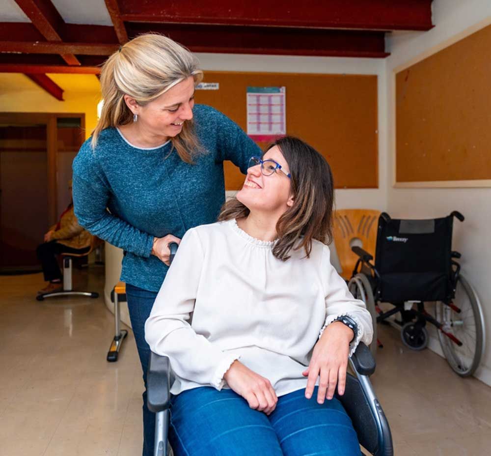 A Woman Is Pushing Another Woman in A Wheelchair — Active Ables Community Services In Tamworth, NSW