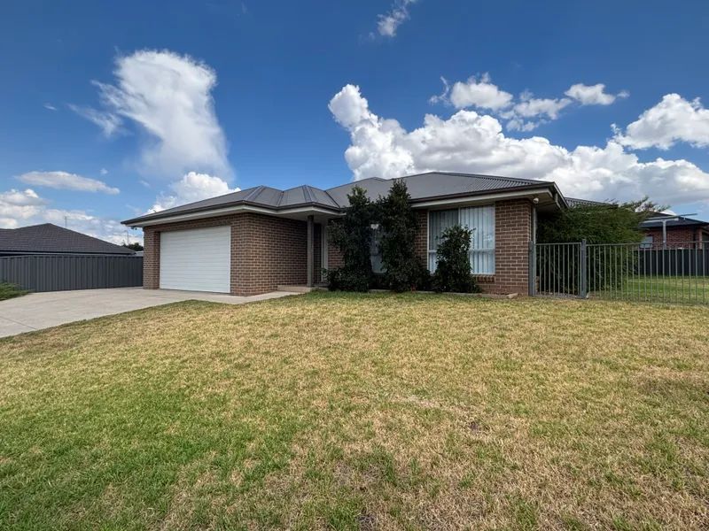 Suburban brick house with a garage, front lawn, and partly cloudy blue sky — Active Ables Community Services In Tamworth, NSW
