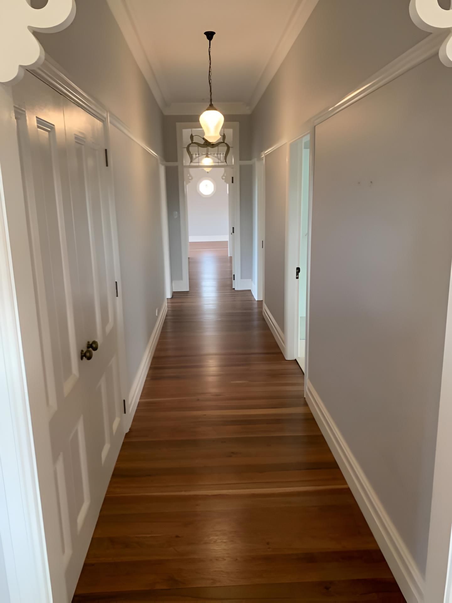 A Long Hallway With Wooden Floors And White Doors — Coolangatta Floor Sanding In Gerringong, NSW