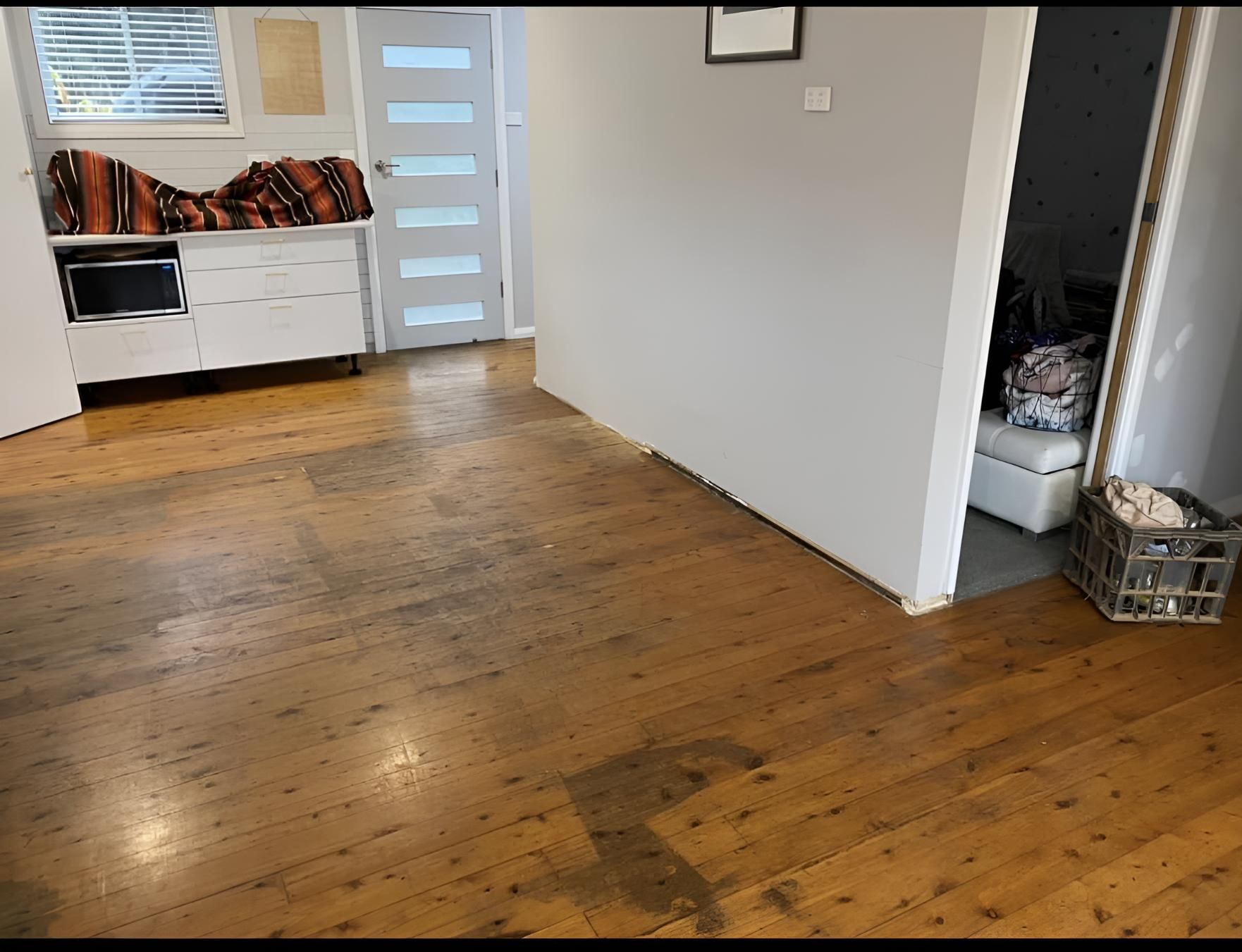 A Living Room With A Wooden Floor And A Basket On The Floor — Coolangatta Floor Sanding In Shoalhaven Heads, NSW