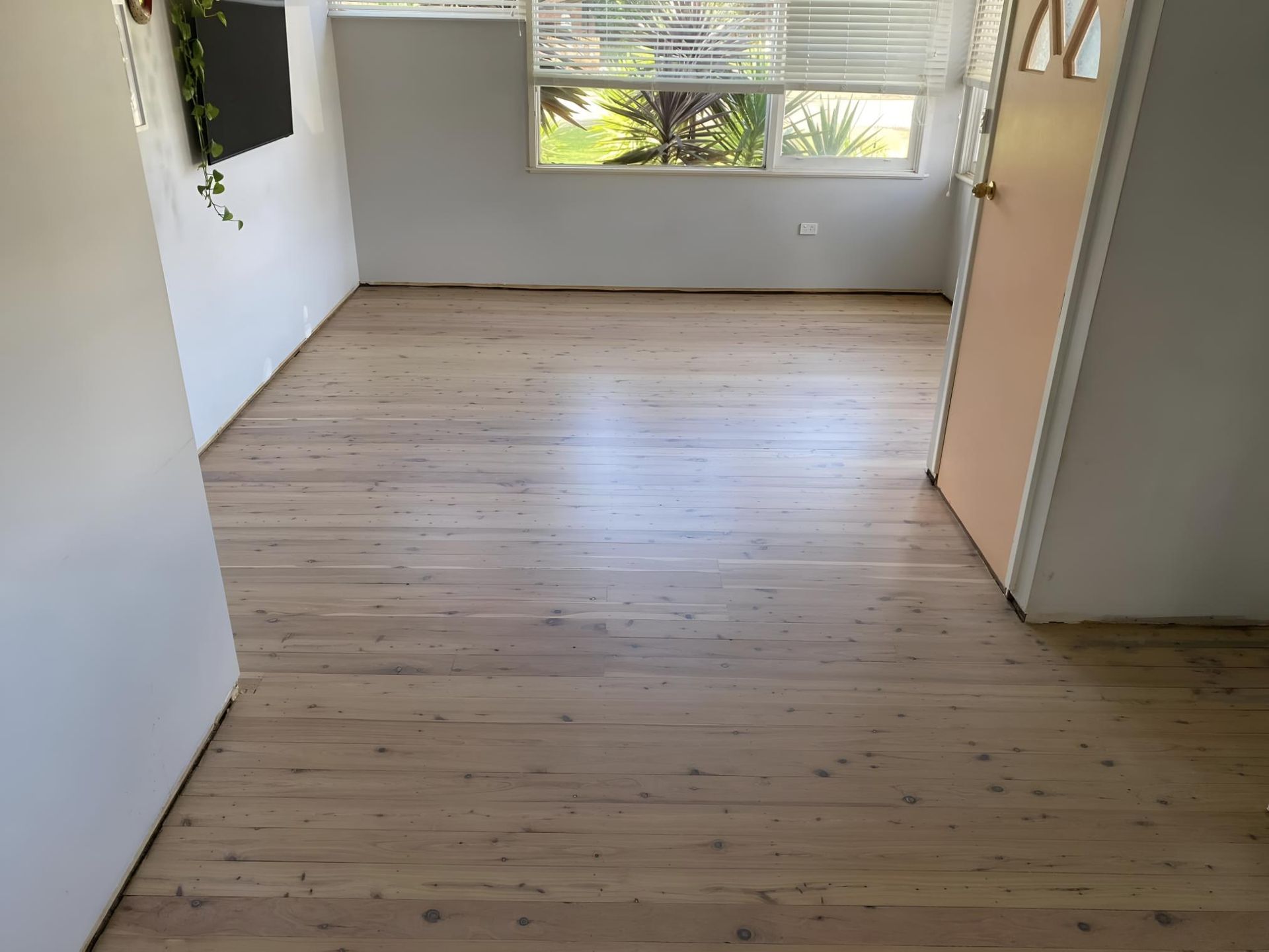 An Empty Room With A Wooden Floor And A Window — Coolangatta Floor Sanding In Shoalhaven Heads, NSW