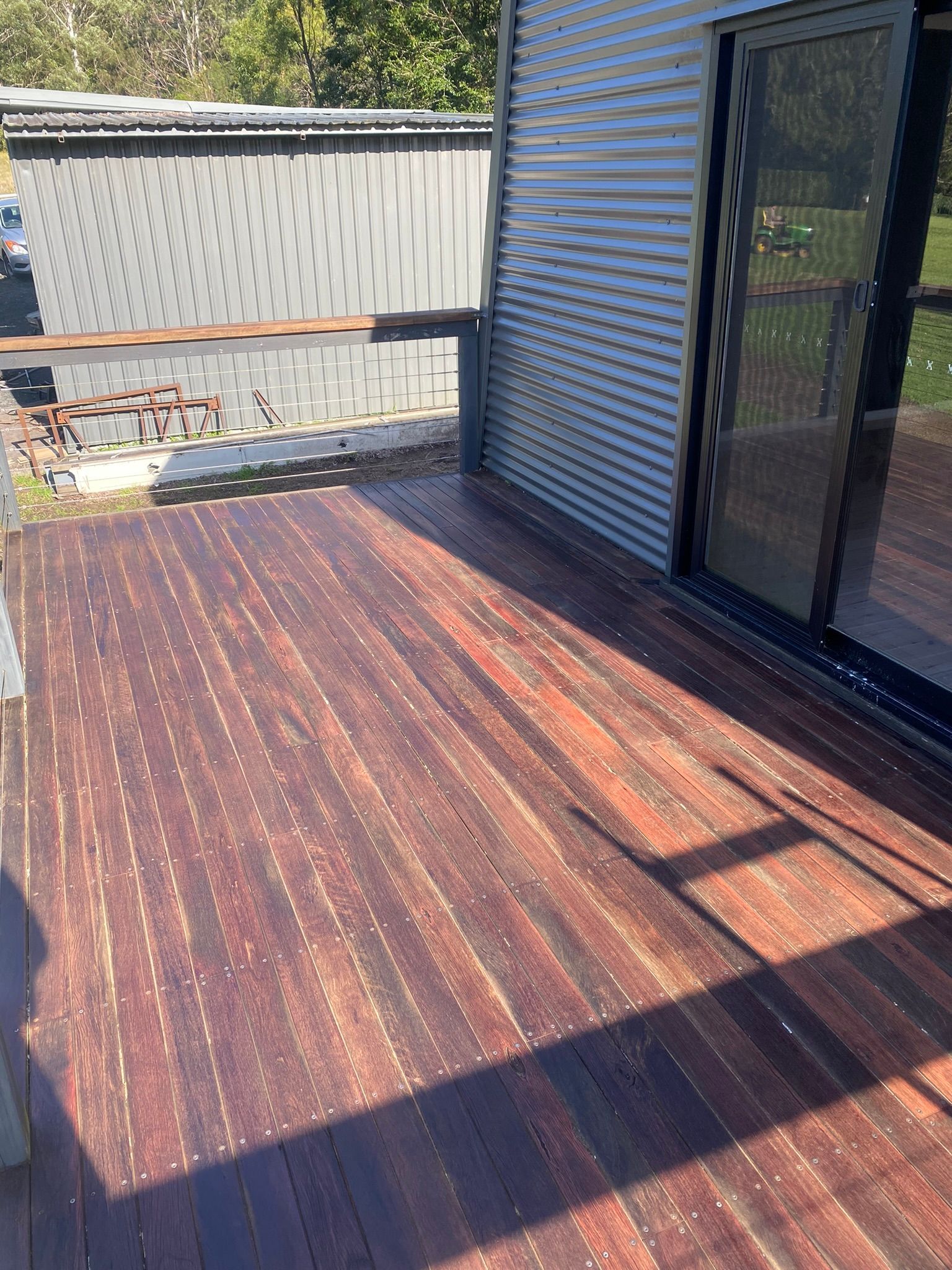 A wooden deck with a sliding glass door and a fence in the background — Coolangatta Floor Sanding In Shoalhaven Heads, NSW