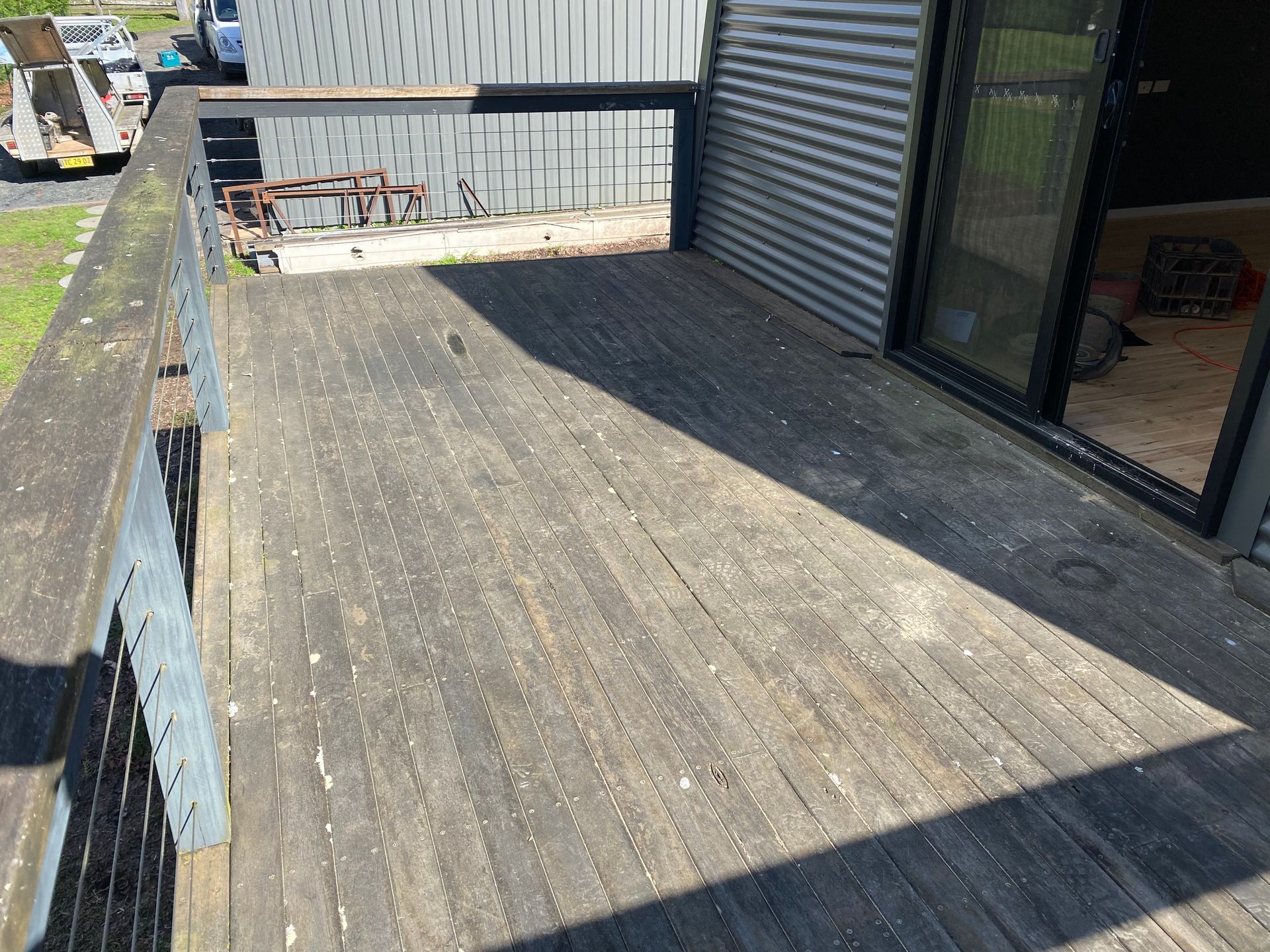 A wooden deck with a metal railing and a sliding glass door — Coolangatta Floor Sanding In Shoalhaven Heads, NSW