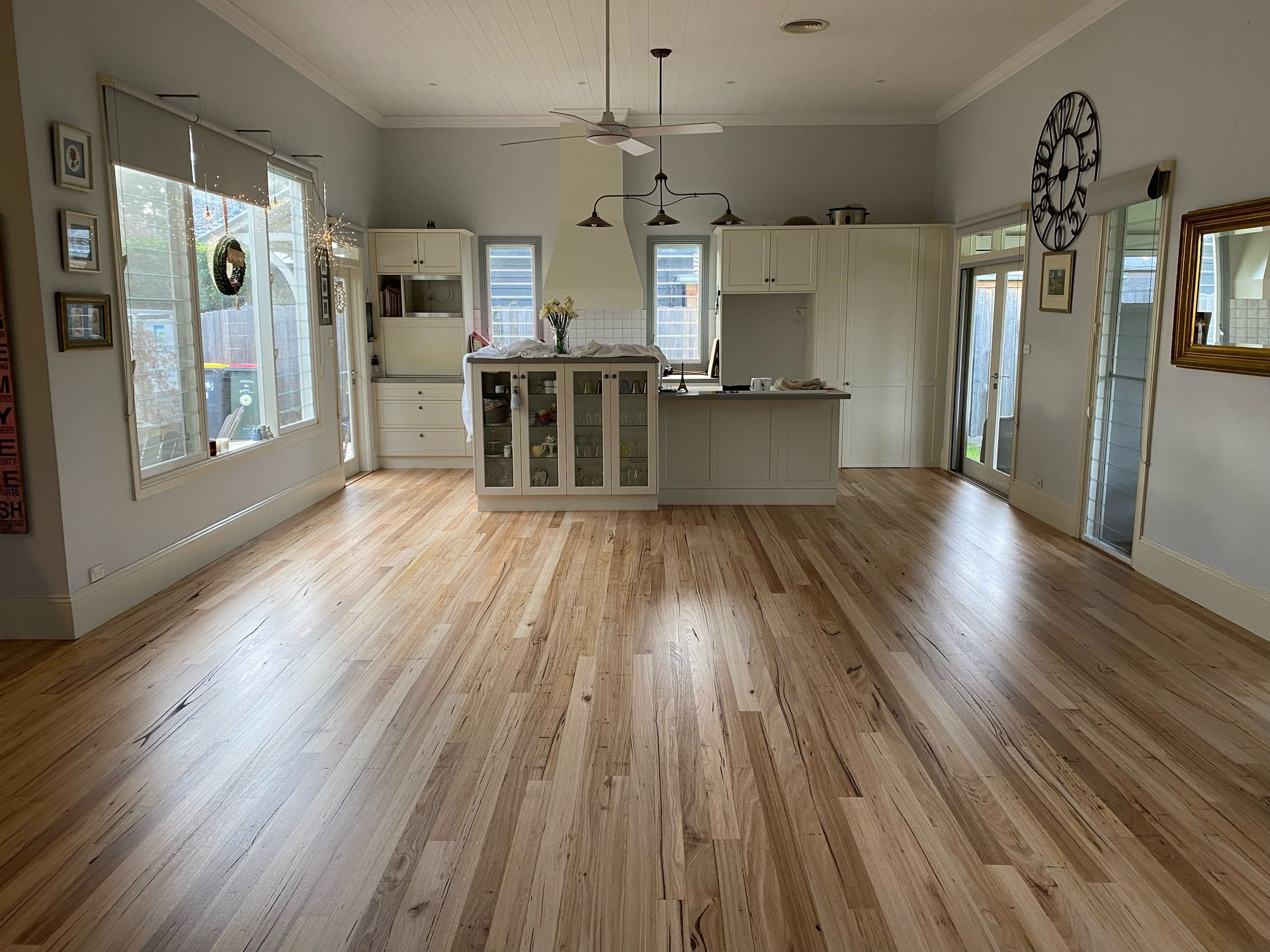 A large room with a wooden floor and a clock on the wall — Coolangatta Floor Sanding In Shoalhaven Heads, NSW