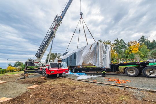 A wooden house is sitting in the middle of a snowy field.