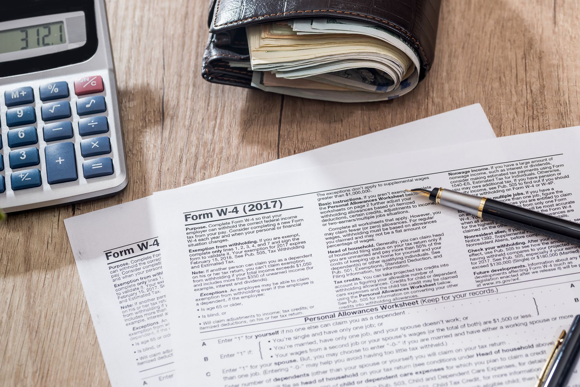 Tax preparation documents on a desk with a calculator and pen