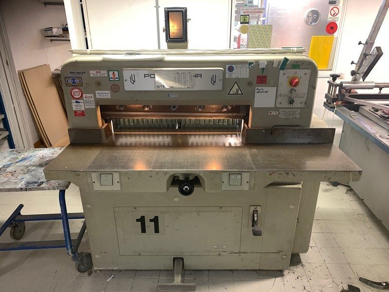 Une machine avec le numéro 11 dessus est posée sur le sol dans une pièce.