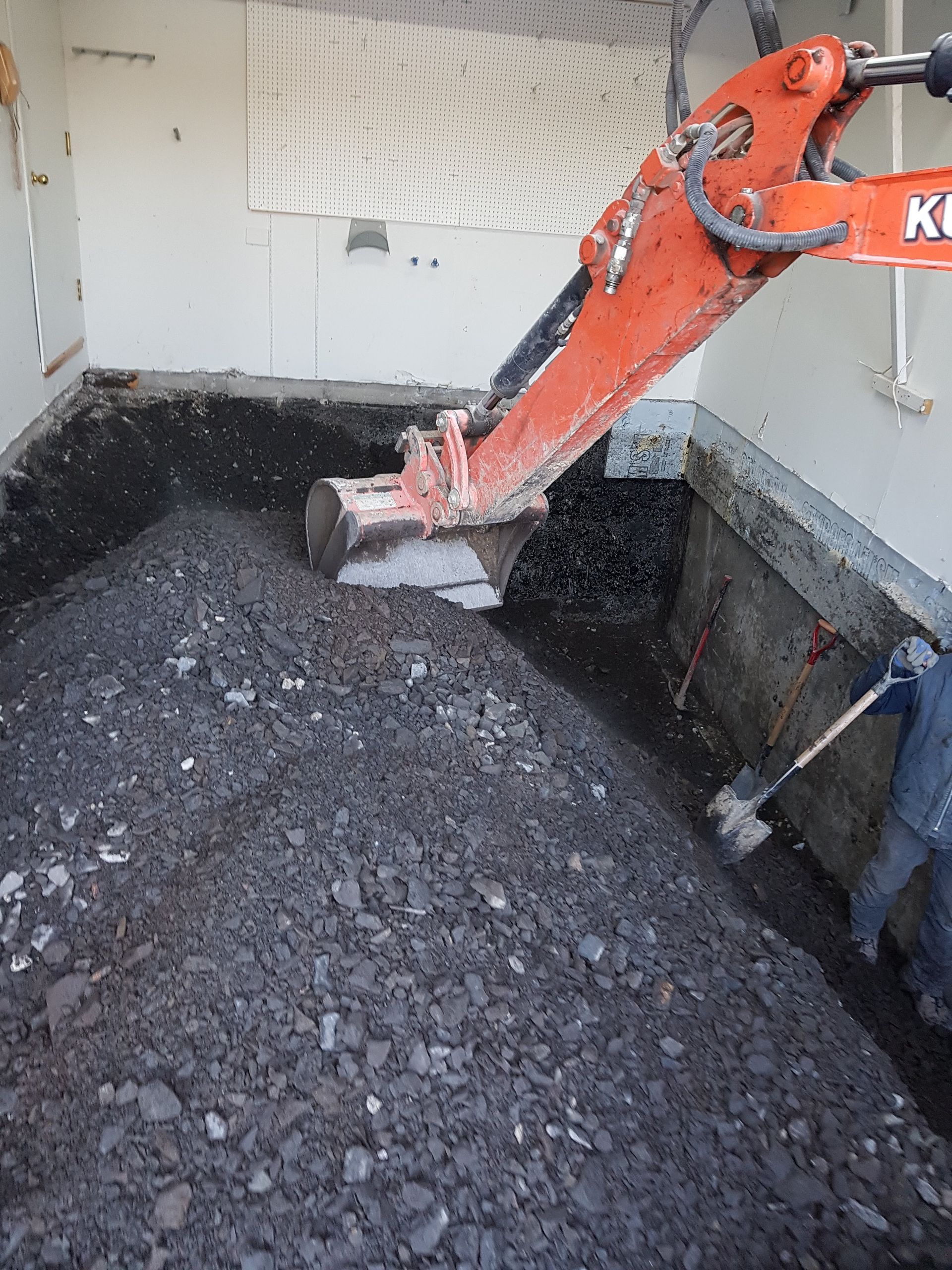 Une excavatrice orange creuse un trou dans le sol