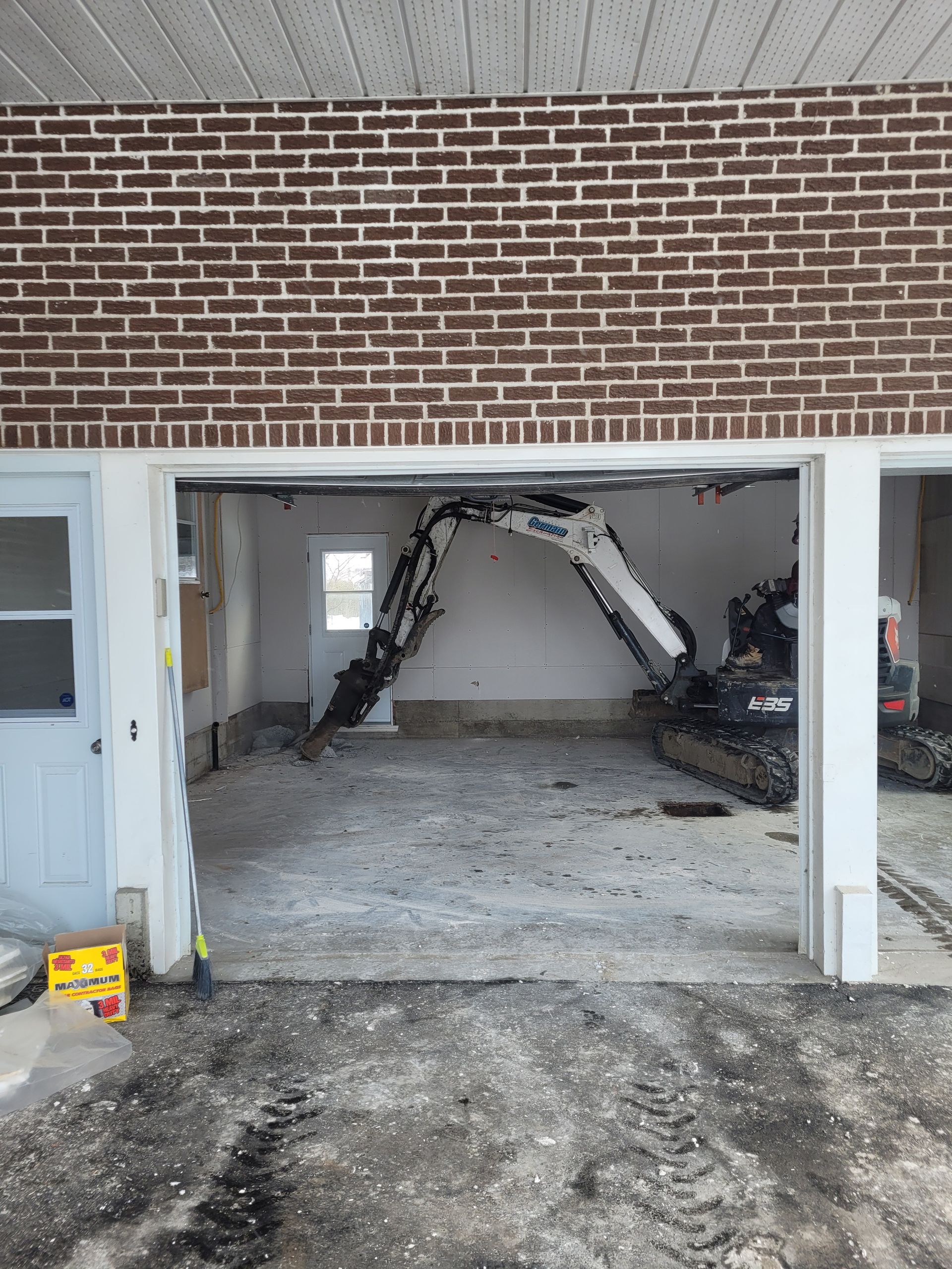 Un garage en briques avec une excavatrice à l'intérieur