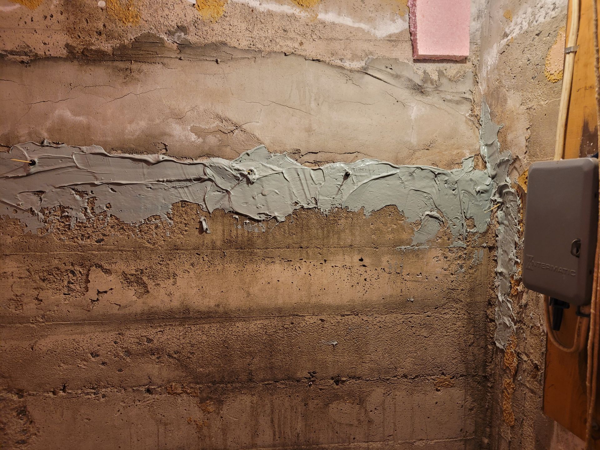 Un mur en béton avec quelques morceaux de plâtre dessus