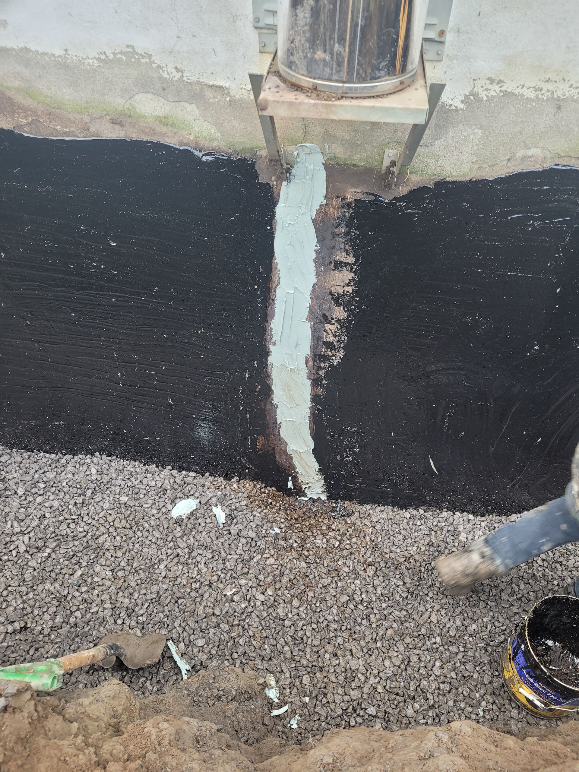 Une personne verse du béton dans un trou dans le sol