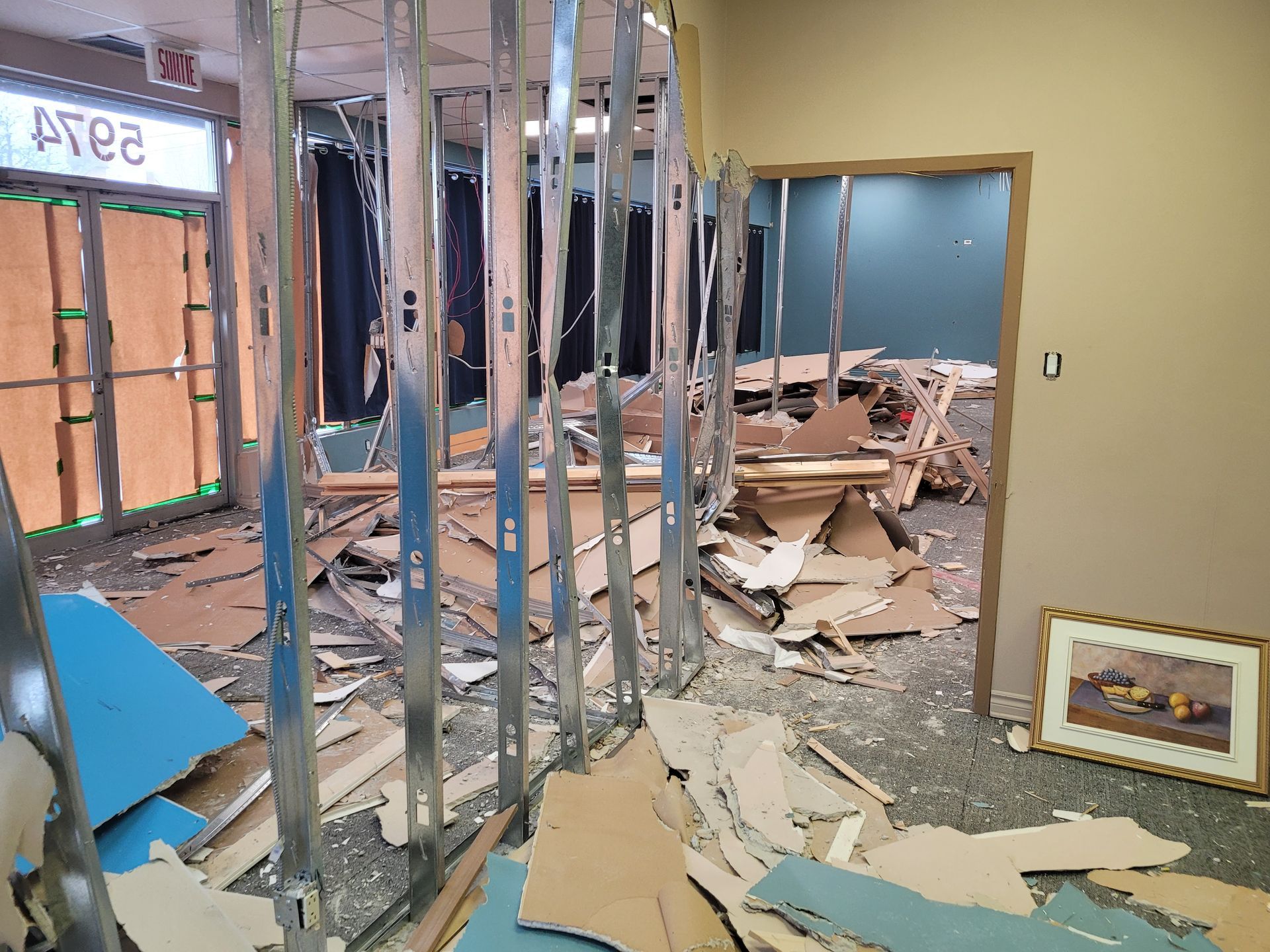 Une pièce avec beaucoup de carton et une image sur le sol.